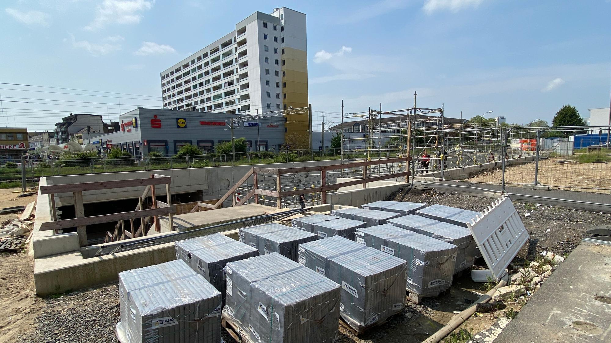 Eine Baustelle vor Gleisen und Hochhäusern in Wesseling.