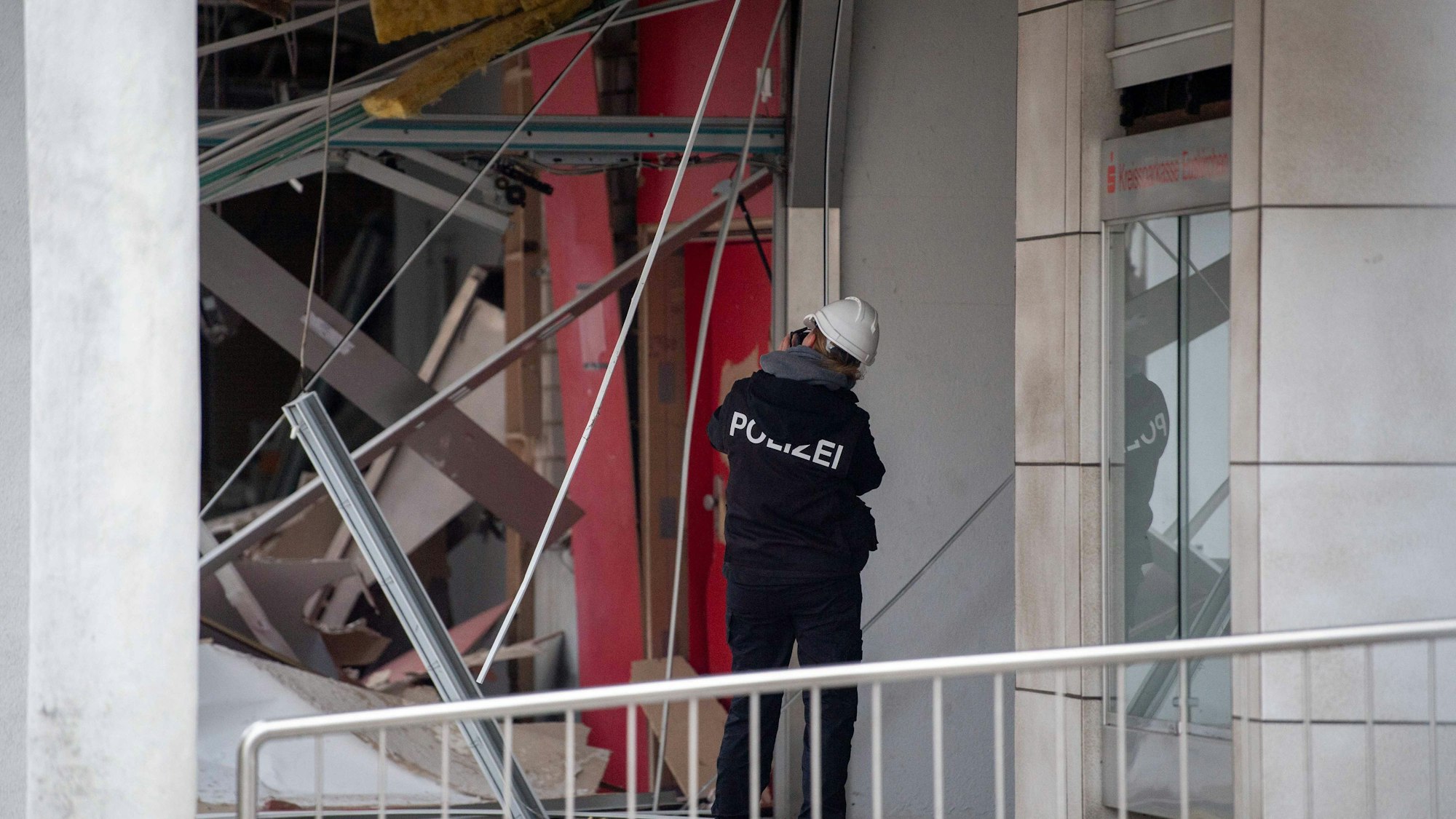 Das Foto zeigt eine Kriminalbeamtin, die die Schäden in der Filiale mithilfe von Fotos dokumentiert.