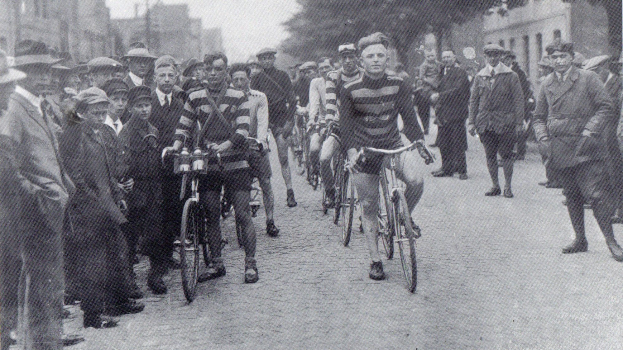 Ein altes Schwarz-Weiß-Foto zeigt ein Radrennen.