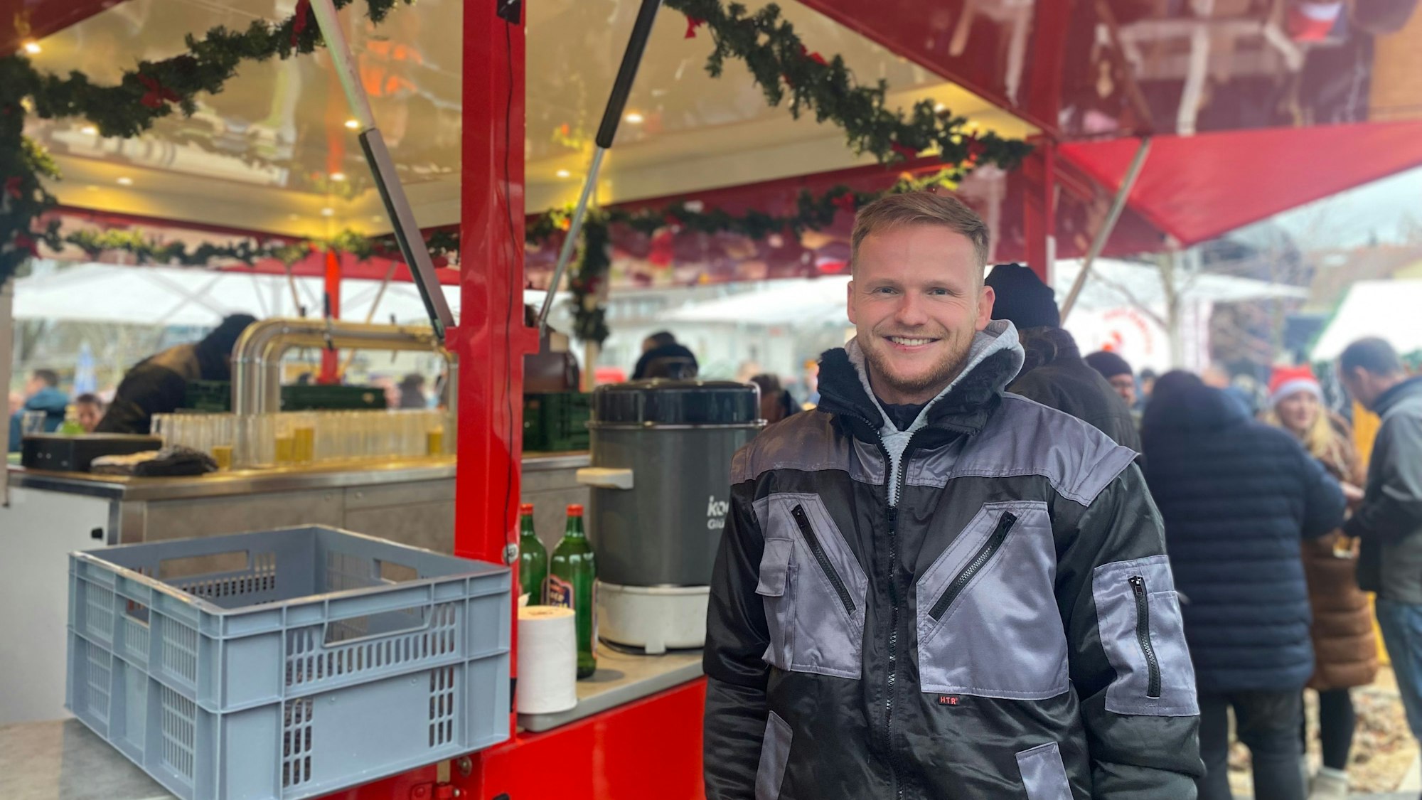 Ein Mann steht vor einem Bierwagen.