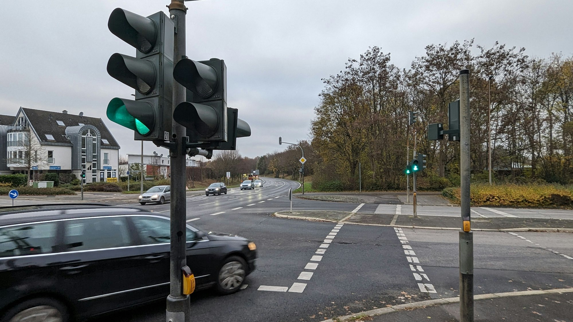 Eine Straßenkreuzung mit Ampel, ein Auto biegt nach rechs über die Fußgängerfurt ab.