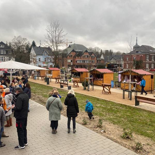 Eine Gruppe von Menschen steht auf einem Weihnachtsmarkt.