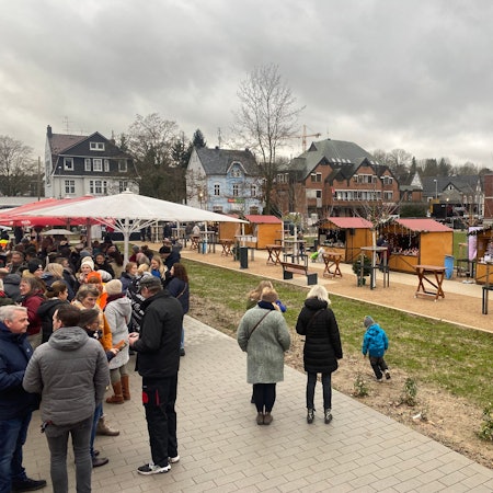 Eine Gruppe von Menschen steht auf einem Weihnachtsmarkt.