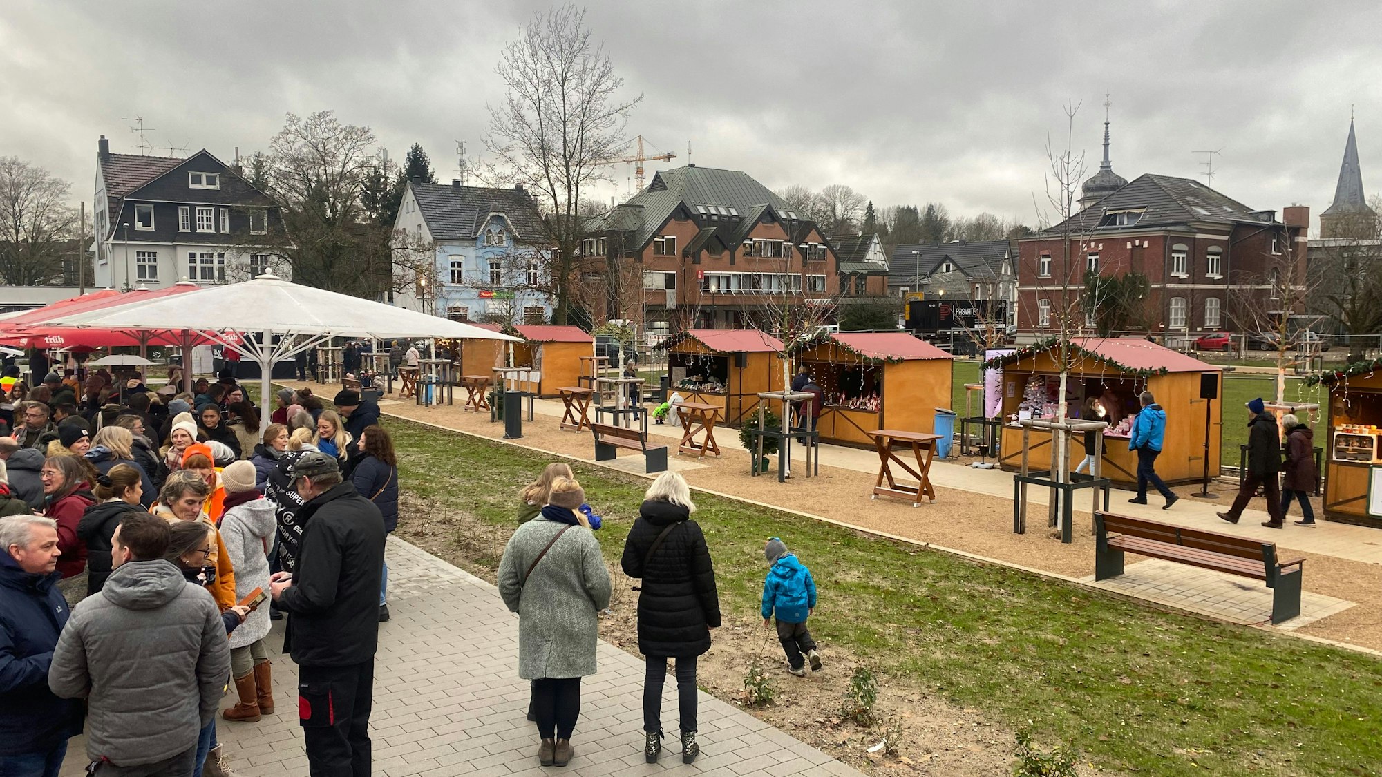 Eine Gruppe von Menschen steht auf einem Weihnachtsmarkt.