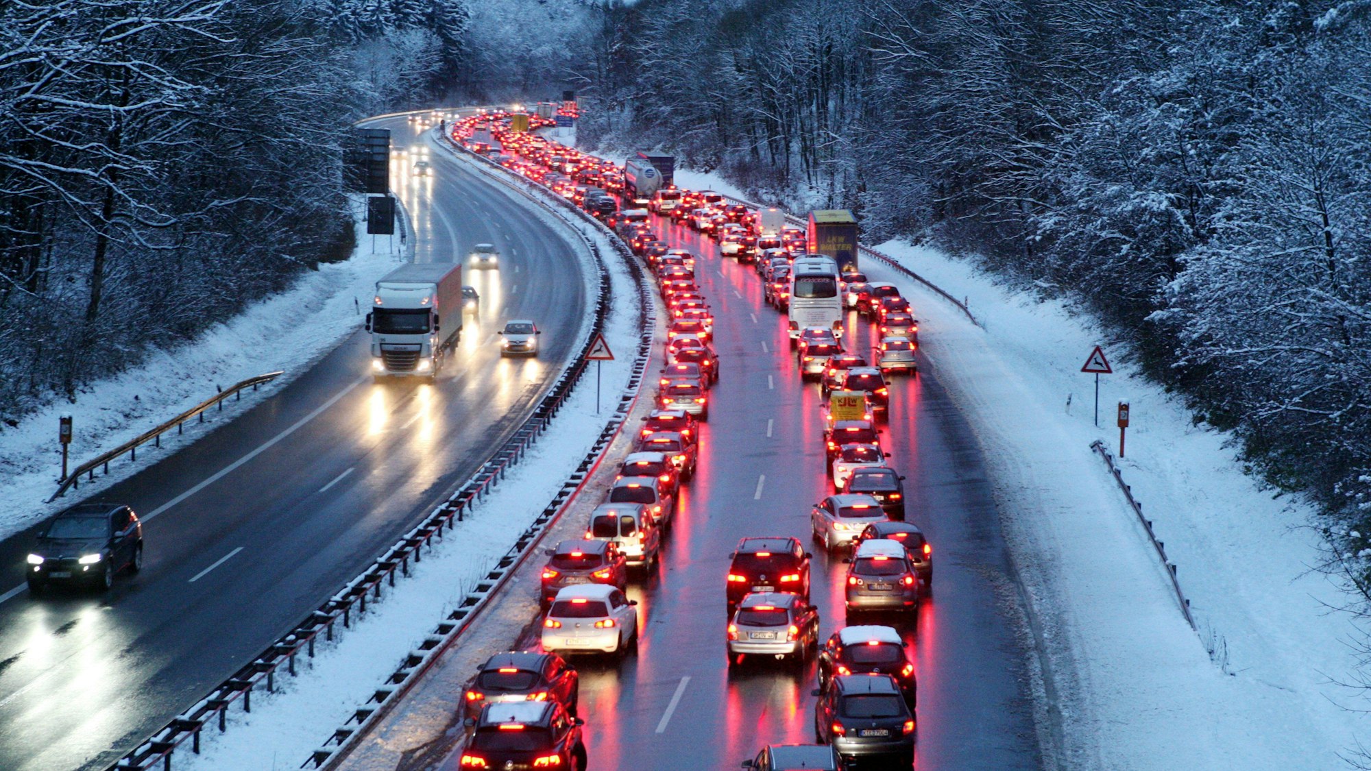 Die A4 im Winter in Rhein-Berg: Schnee liegt am Straßenrand, in einer Fahrtrichtung staut es sich.