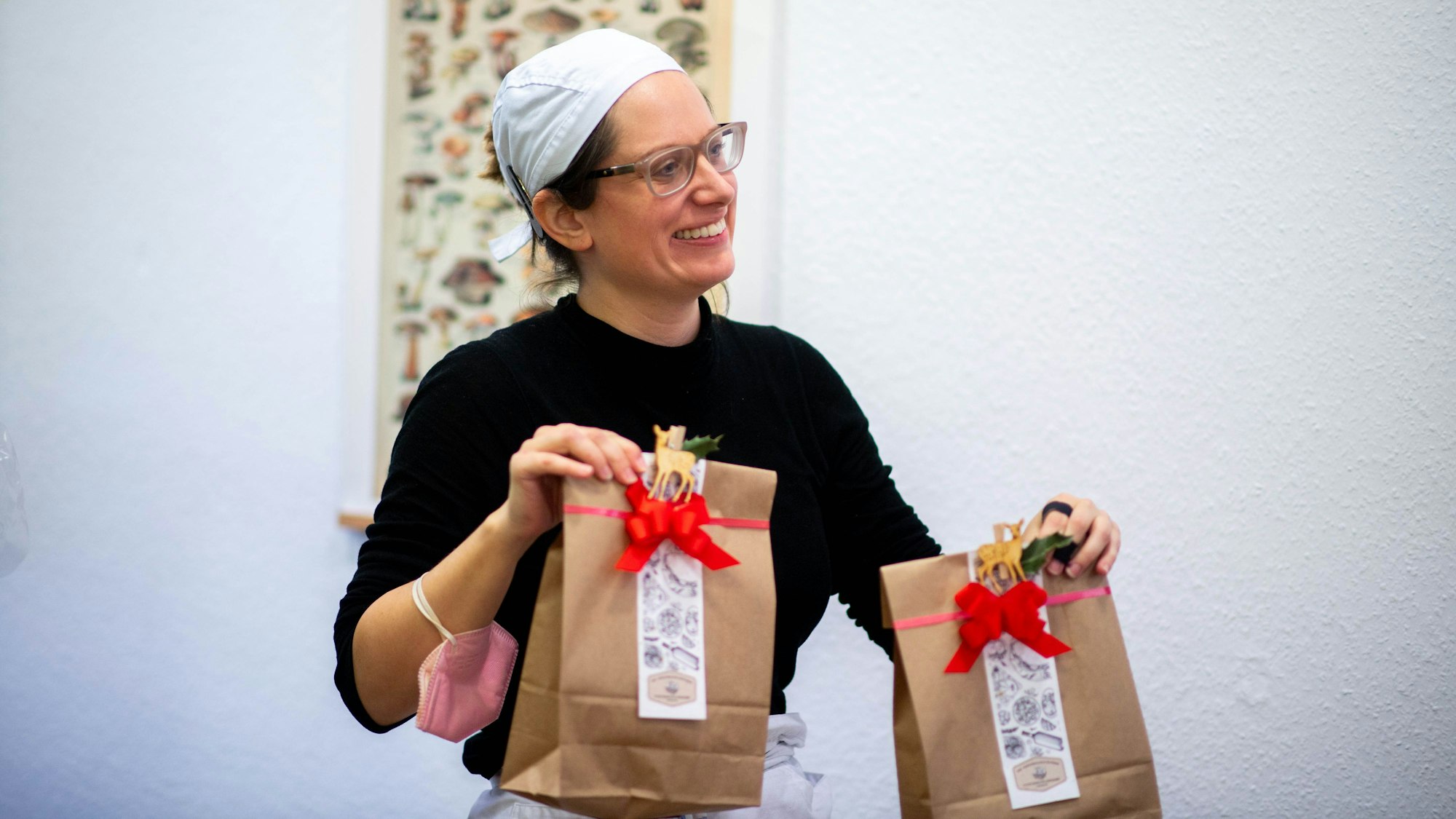 Anika-Helena Wübben trägt zwei Geschenktüten für eine Kundin durch den Laden.