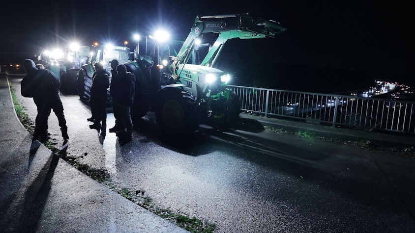 A3 bei Düsseldorf: Landwirte stehen mit Traktoren auf einer Brücke, um gegen die geplante Kürzung des Agrardiesels zu protestieren.