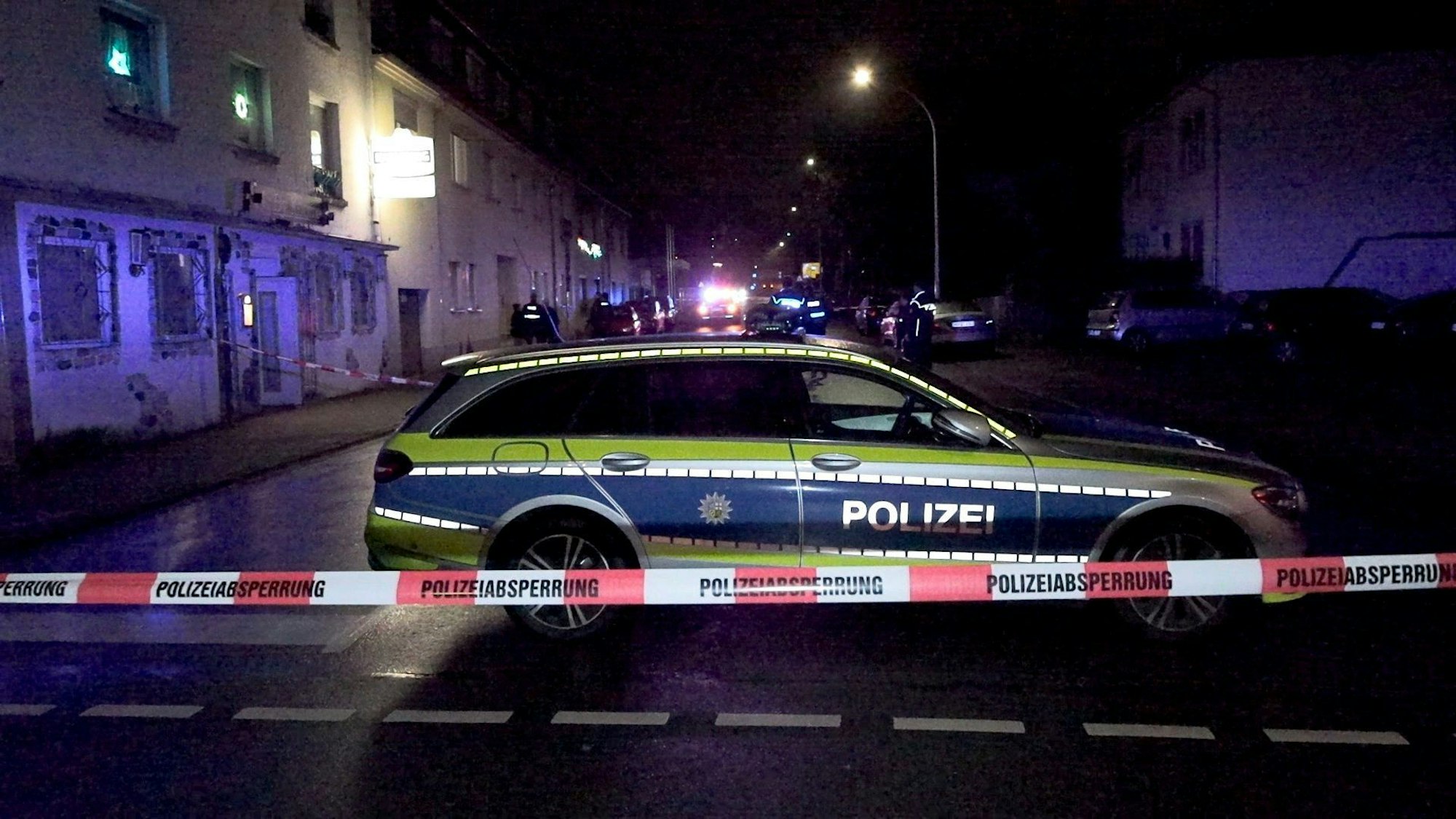 19.12.2023, Saarland, Neunkirchen: Einsatzkräfte der Polizei sind an einem mit Absperrband gesicherten Tatort vor einem Lokal im Einsatzt. Vor einer Kneipe im saarländischen Neunkirchen sind am Dienstagabend Schüsse gefallen. Ein 53-jähriger Mann wurde durch einen Schuss am Bein verletzt, wie ein Sprecher der Polizei sagte. Es habe vor dem Lokal zwei Schüsse gegeben. Der Täter war den Angaben zufolge zunächst flüchtig. Nach ihm wurde am Abend gefahndet Foto: Thorsten Kremers/dpa +++ dpa-Bildfunk +++