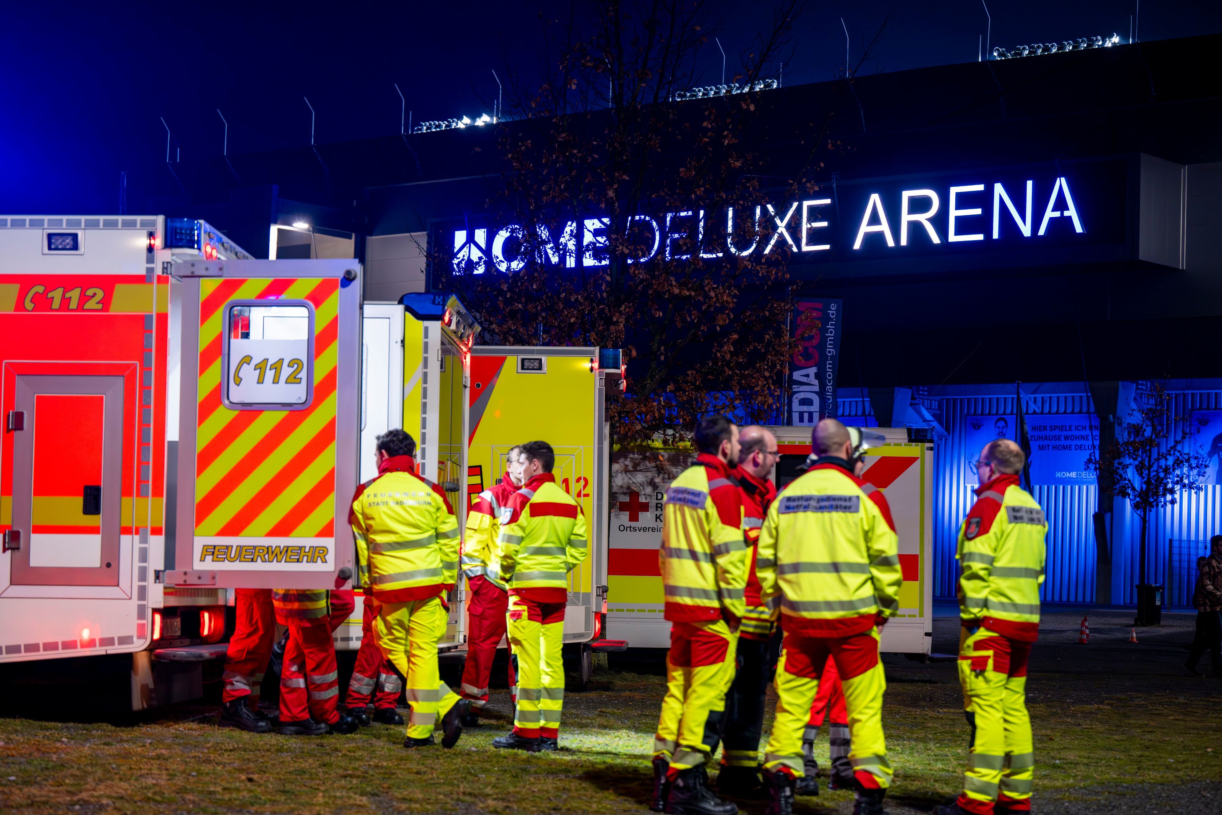 Sanitäter stehen vor dem Stadion in Paderborn bei einem Einsatz vor ihren Rettungswagen.