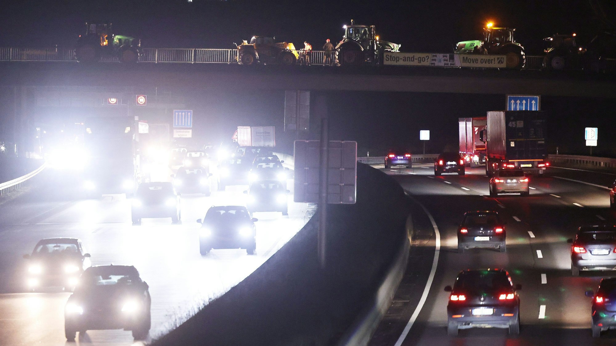 Landwirte stehen mit Traktoren auf einer Brücke über der A3. Die Landwirte zeigen Präsenz wegen aktuellen Plänen der Bundesregierung in Sache Landwirtschaft.