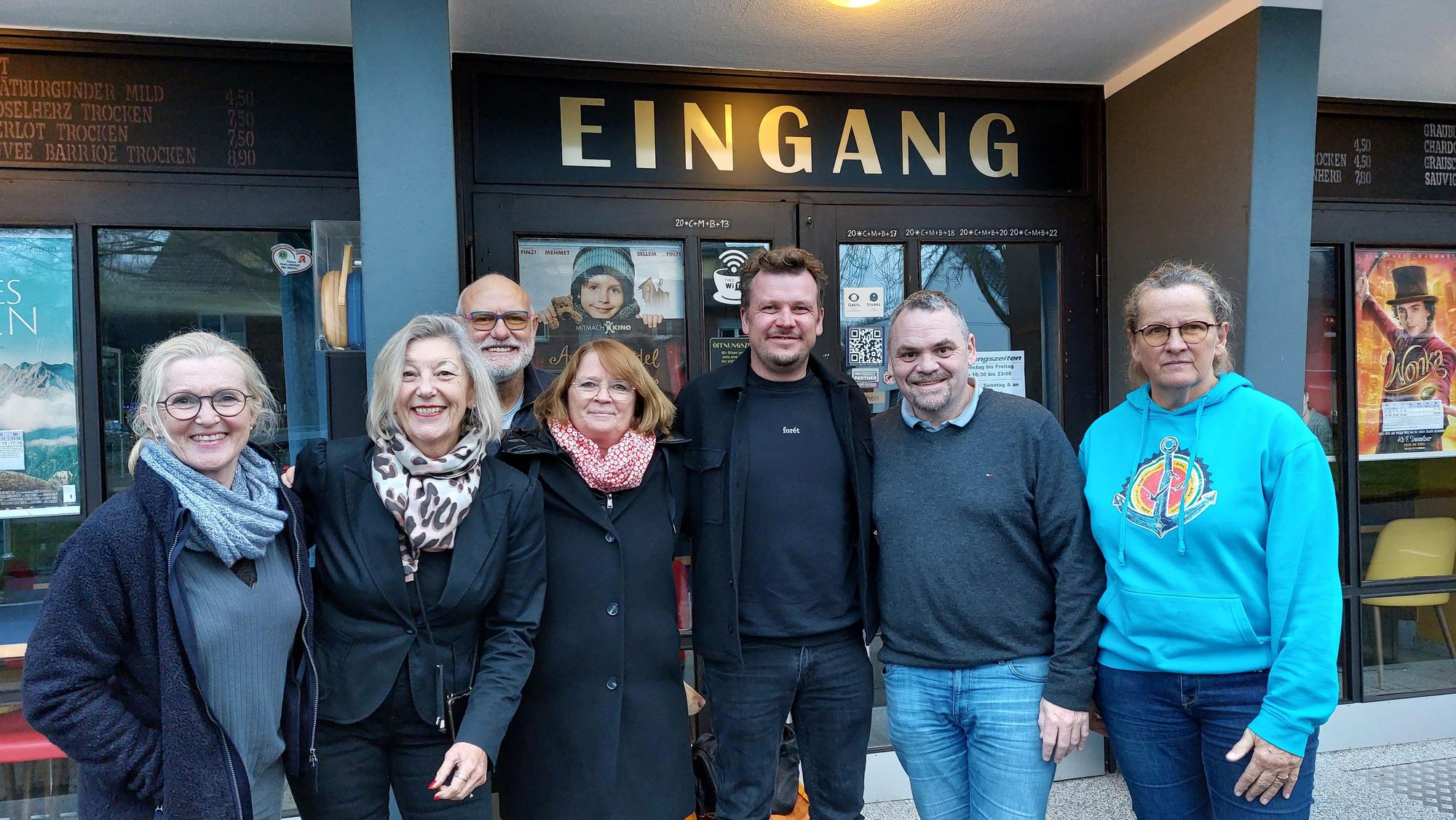 EIne Gruppe von Menschen vor dem Eingang des Berli-Theaters.