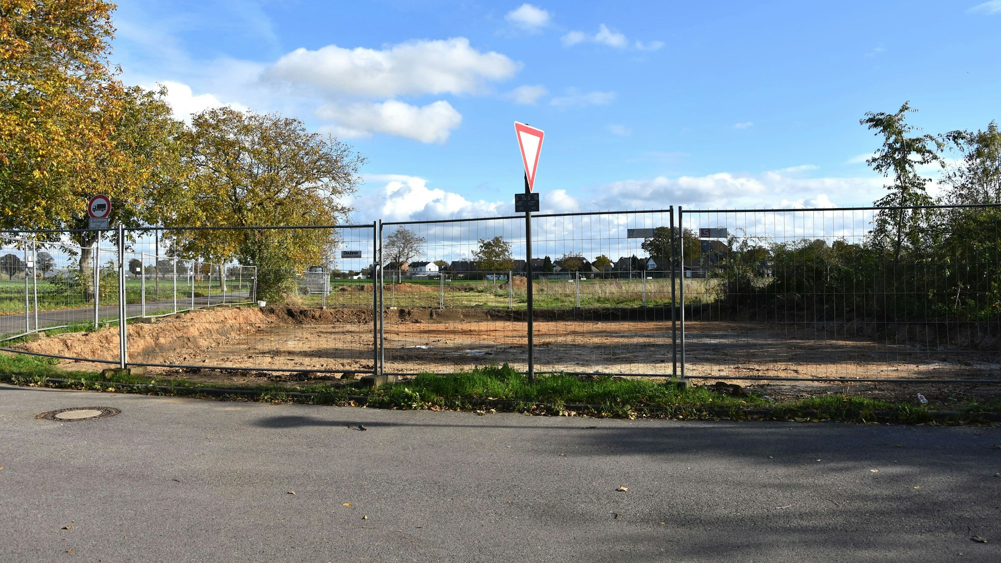 Ein Bauzaun umgibt eine frisch ausgeschachtete Baustelle.