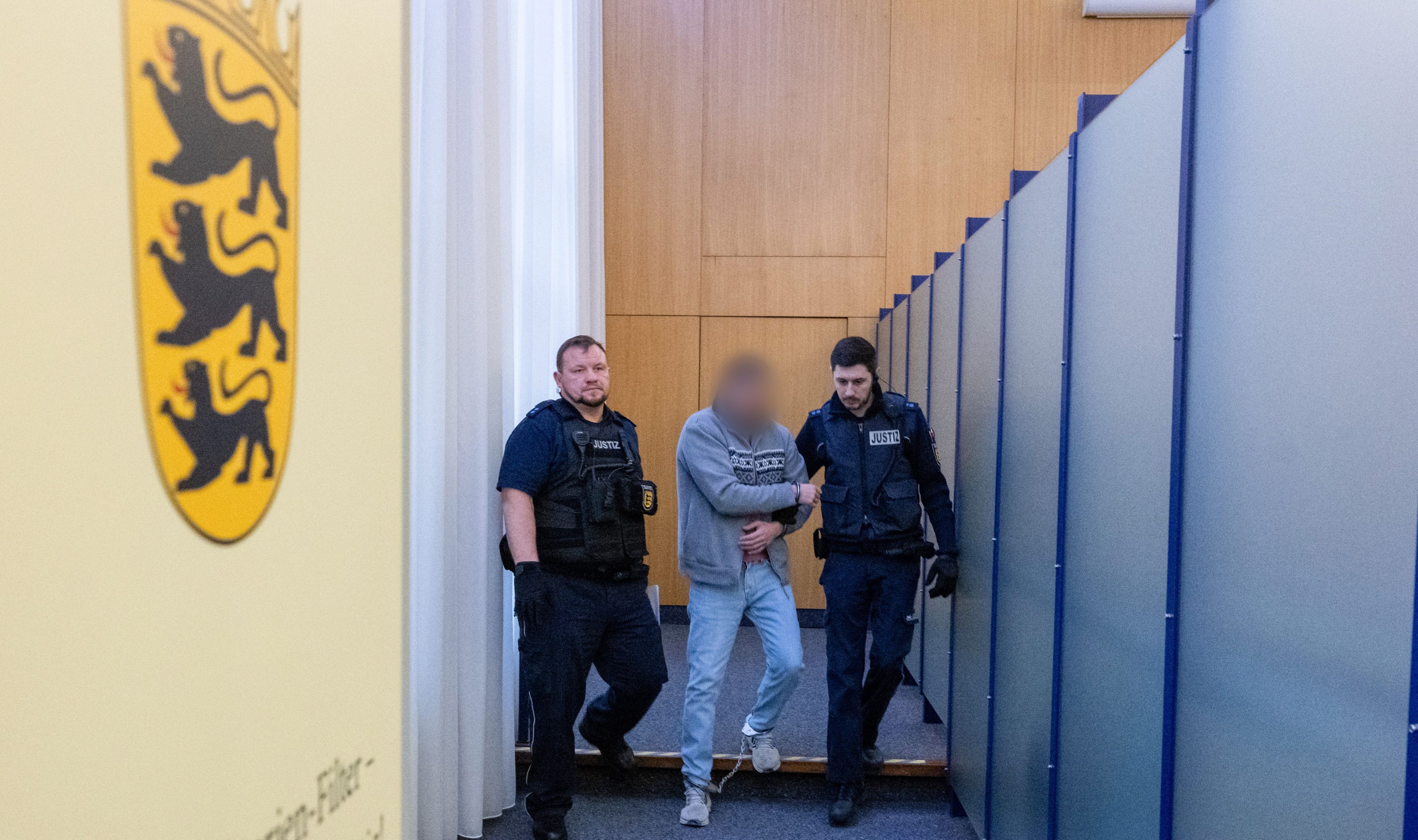 Ulm: Justizwachtmeister führen im Landgericht einen Mann an Fuß- unf Handschellen gefesselt in den Sitzungssaal.