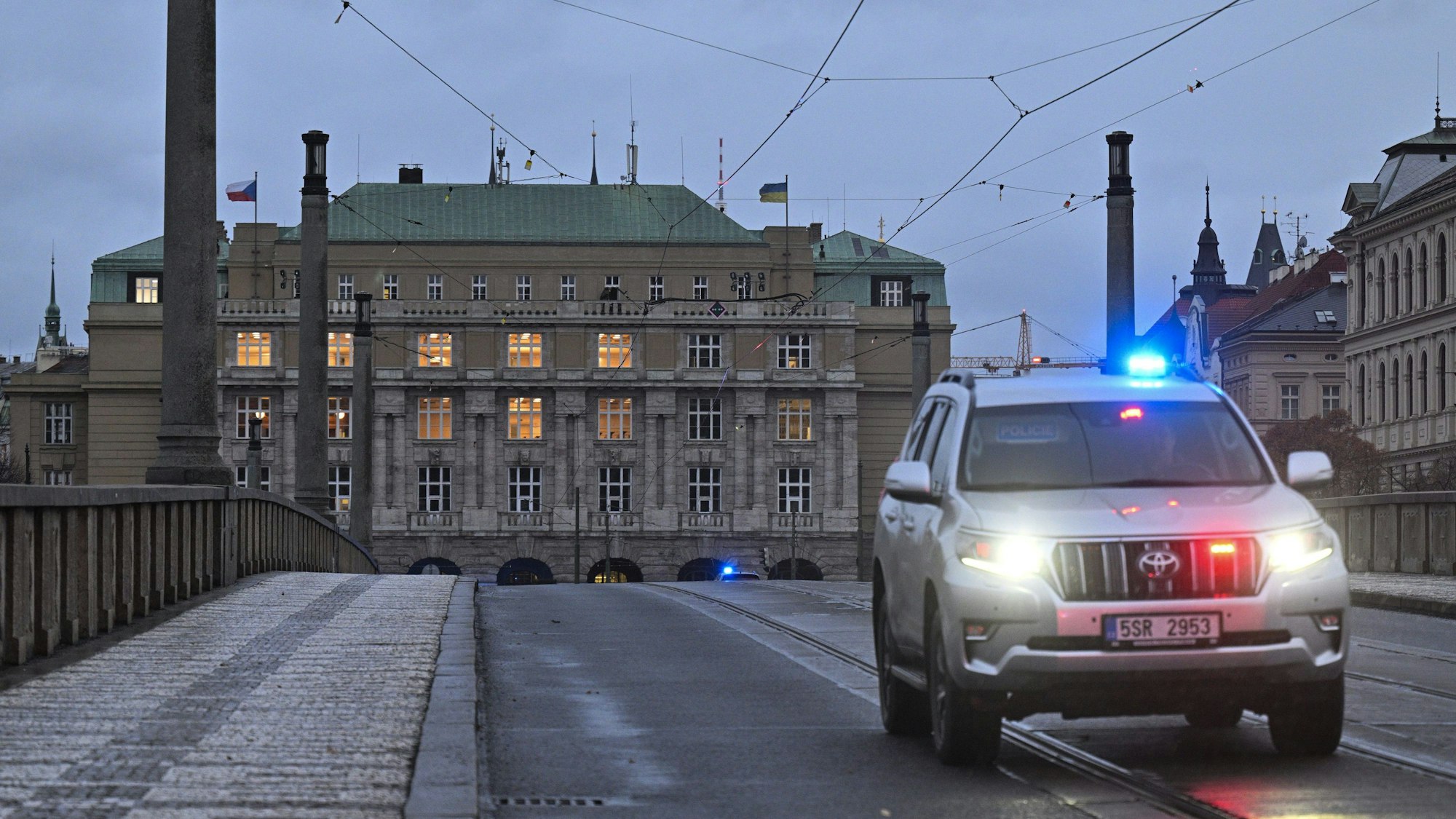 Ein Polizeiauto fährt über die gesperrte Mánes-Brücke.