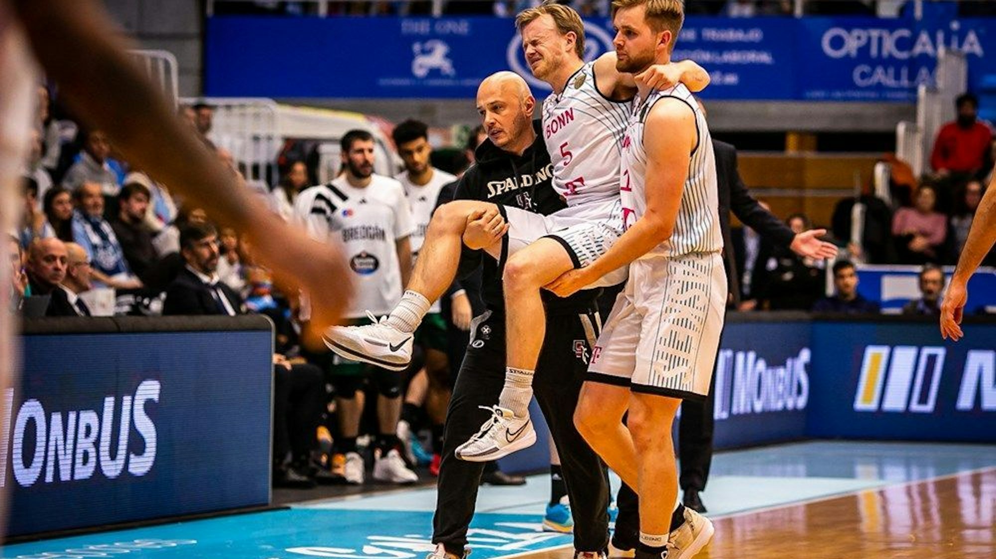 Harald Frey wird von Till Pape und Baskets-Physiotherapeut Bogdan Suciu vom Feld getragen.