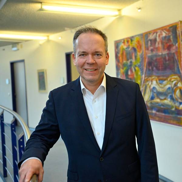 Klaus Grootens vor einem bunten Gemälde im Gummersbacher Kreishaus.
