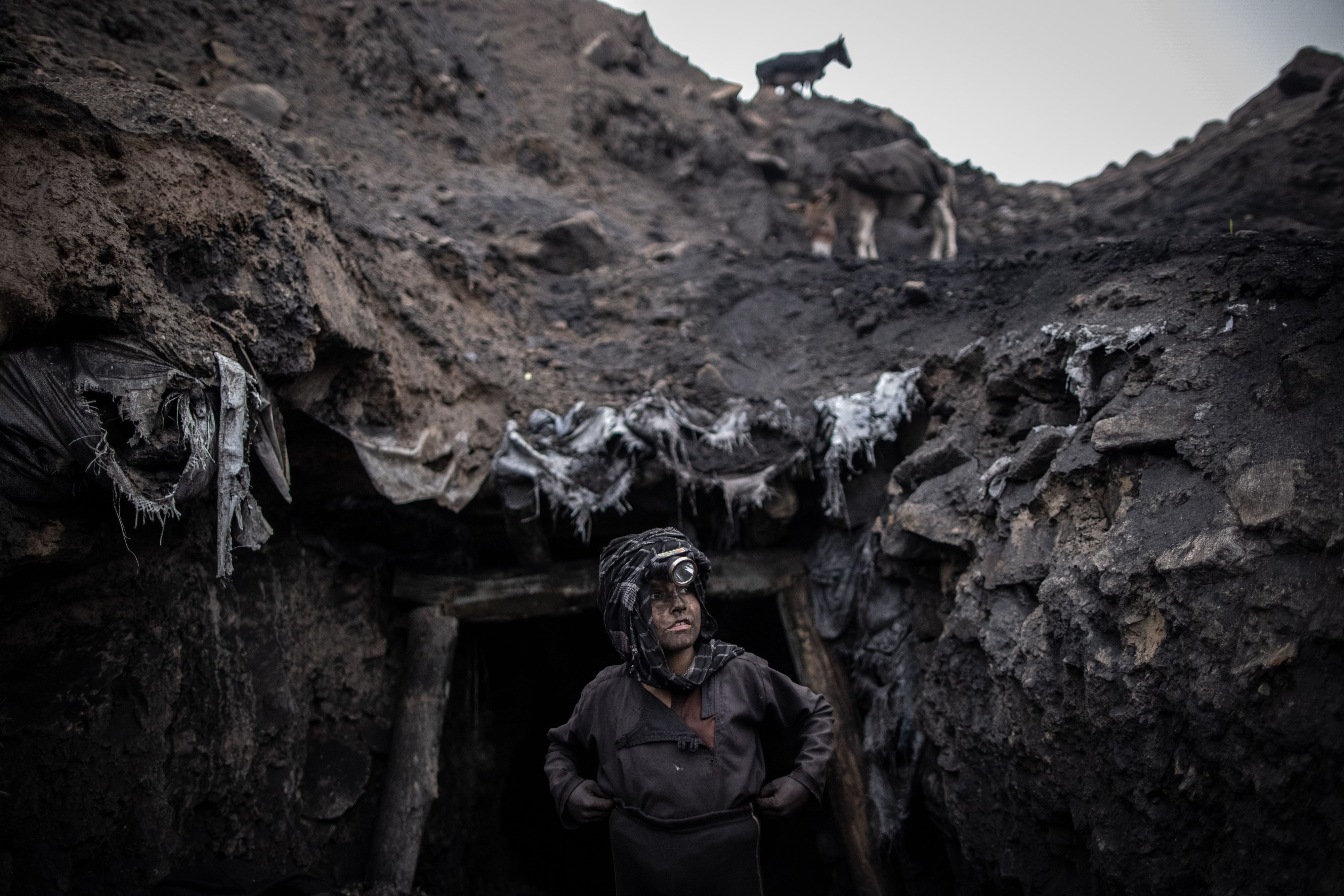Das Foto zeigt einen Jungen, der als Bergarbeiter arbeitet, steht vor einem informellen Kohlebergwerk in Chinarak in der afghanischen Provinz Baghlan.