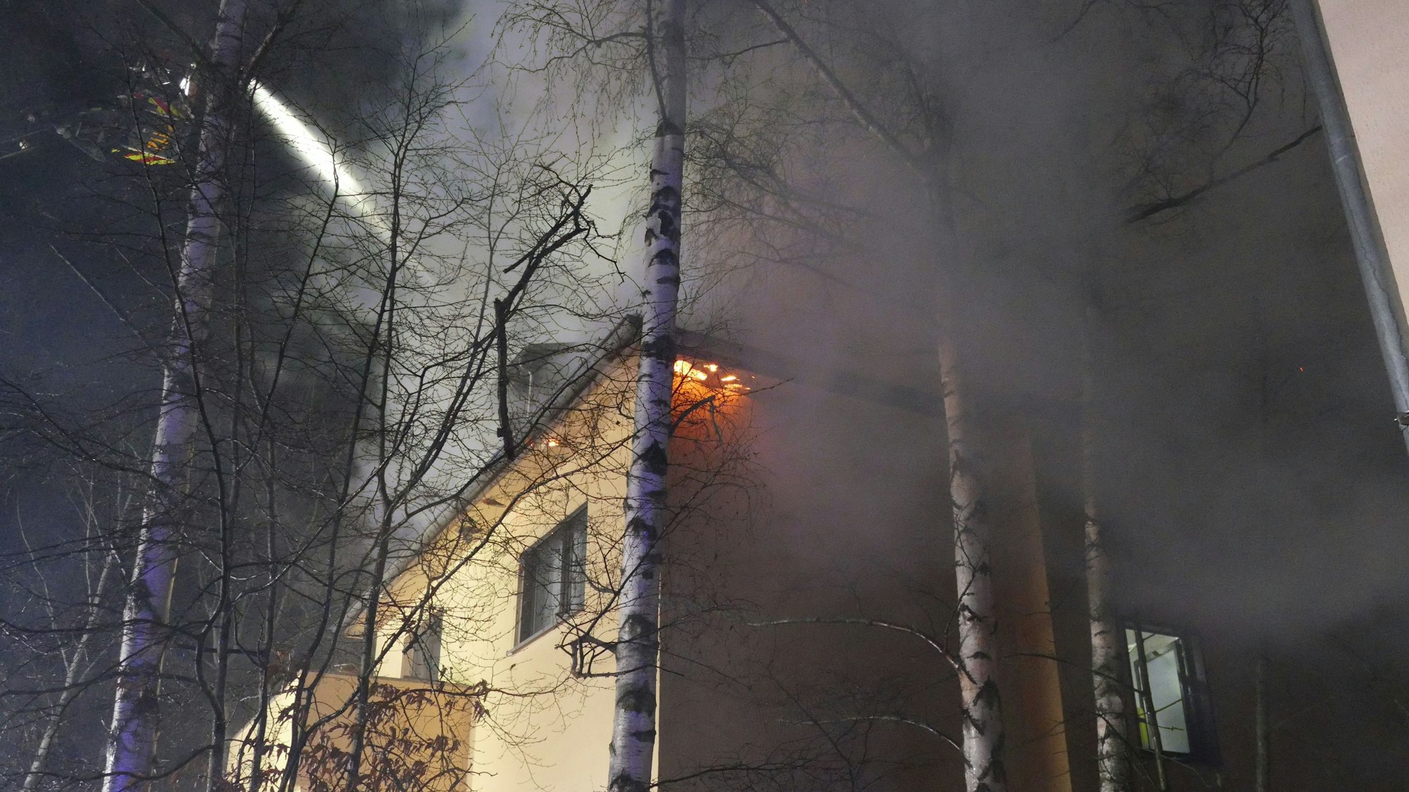 Ein brennender Dachstuhl wird von der Feuerwehr gelöscht.