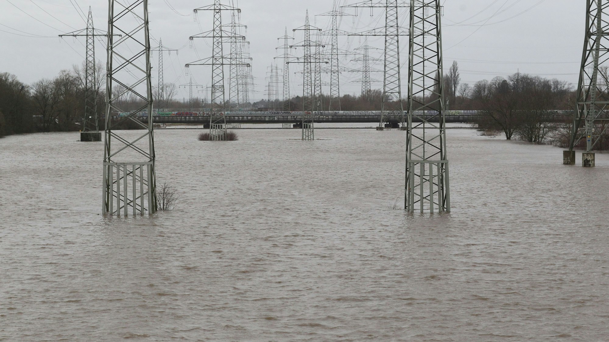 Hochspannungsleitungen stehen im Wasser.