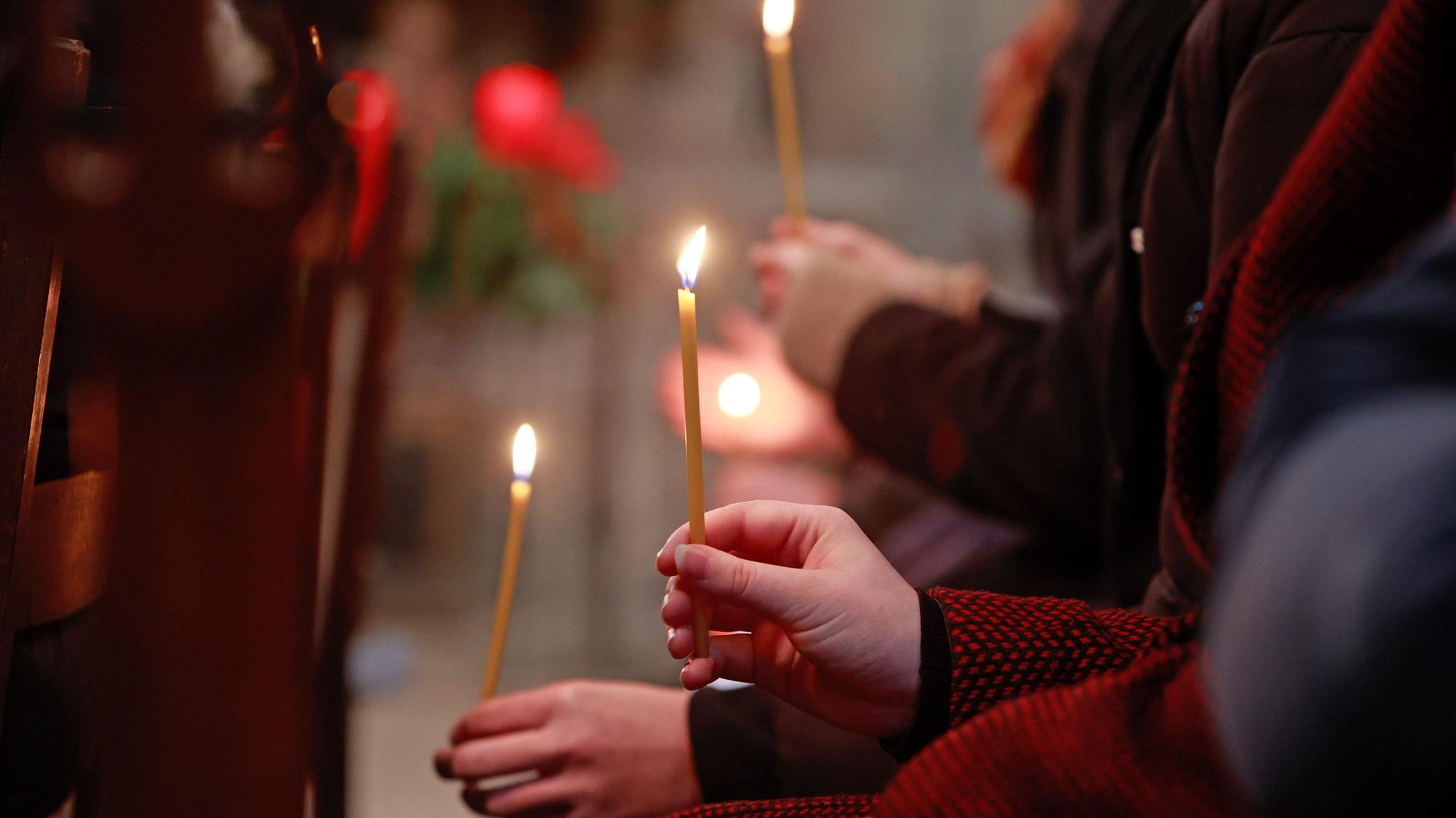 17.12.2023, Sachsen-Anhalt, Halberstadt: Teilnehmer eines ökumenischen Gottesdienstes halten im Dom St. Sixtus und St. Stephanus Kerzen, die das Friedenslicht aus Betlehem symbolisieren. Das Motto der Friedenslicht-Aktion in diesem Jahr lautet «Auf der Suche nach Frieden». Die Aktion Friedenslicht wurde 1986 vom österreichischen Rundfunk (ORF) ins Leben gerufen, um es an «alle Menschen guten Willens» zu verteilen. Seitdem entzündet jedes Jahr ein Kind die Flamme in der Geburtsgrotte Jesu in Bethlehem. Foto: Matthias Bein/dpa +++ dpa-Bildfunk +++
