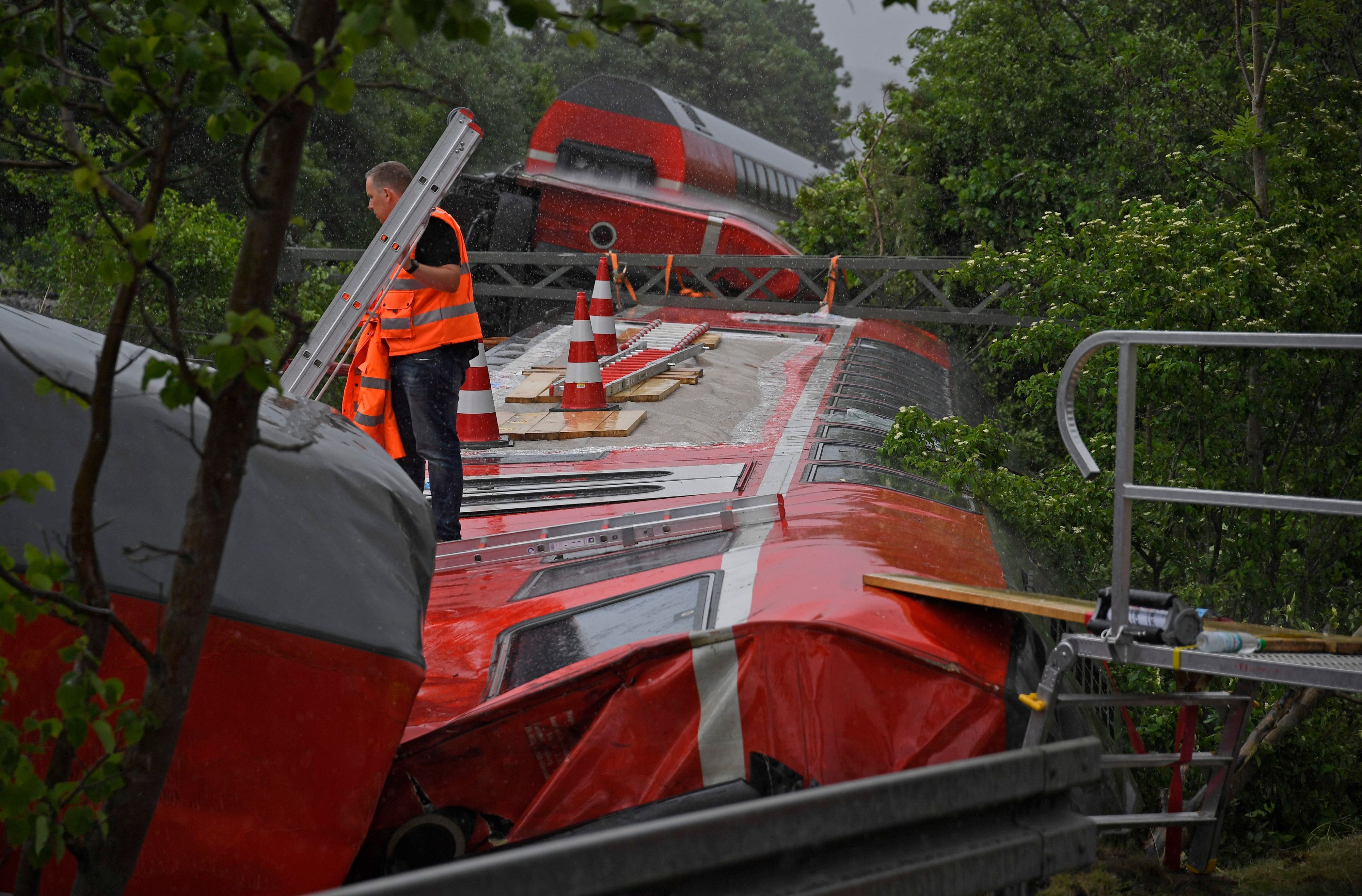 Zugunglück bei Garmisch-Patenkirchen: Ein Arbeiter steht auf einem Waggon, der bei dem schweren Zugunglück entgleist und auf der Seite gelandet war. (Archivbild)