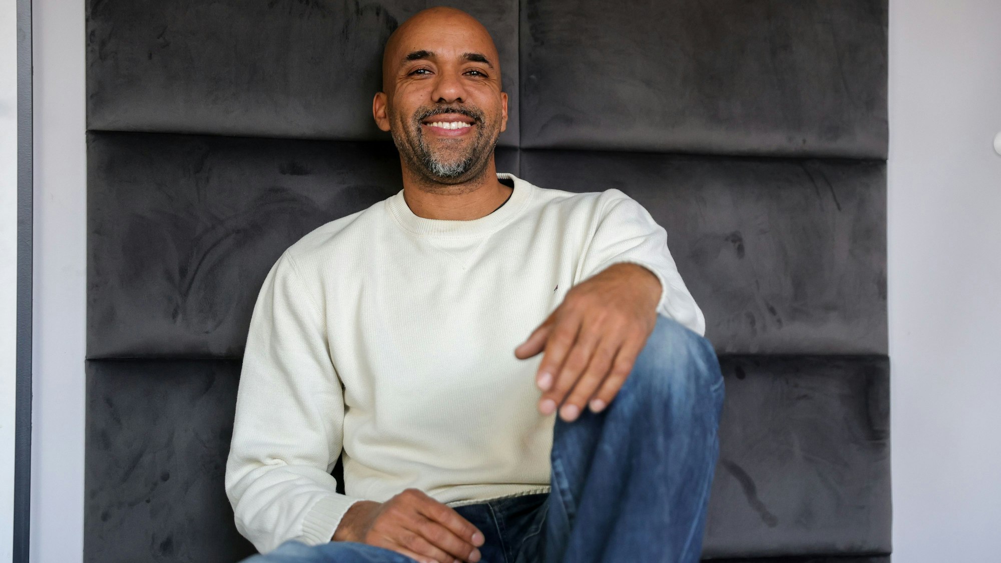Clifford Opoku-Afari sitzt vor einer Wand in seinem Studio.