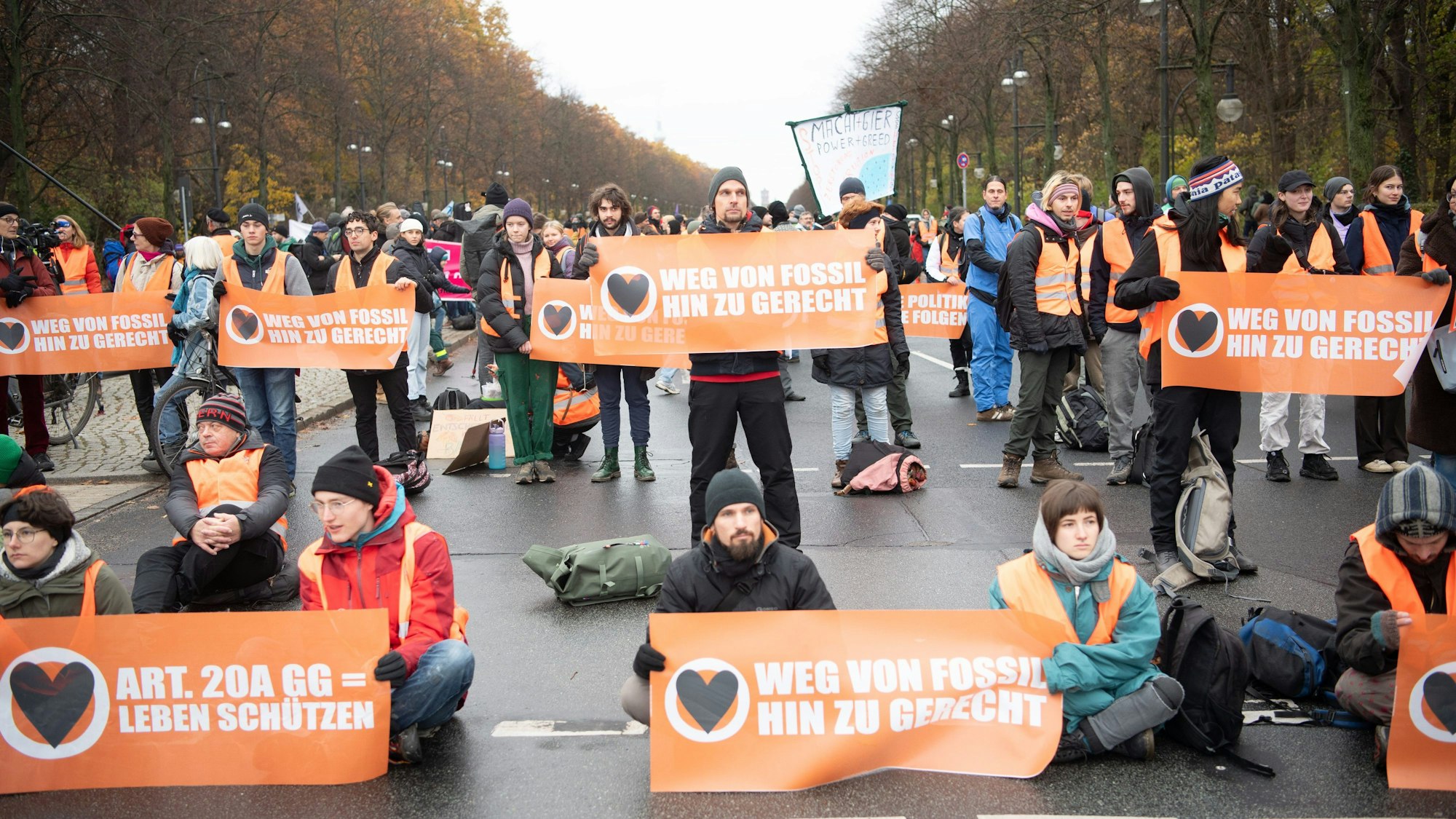 ARCHIV - 25.11.2023, Berlin: Aktivisten der Klimaschutzgruppe "Letzte Generation" und anderer Gruppierungen blockieren die Straße des 17. Juni. Das Deutsche Institut für Menschenrechte (DIMR) hat die Präventivhaft für Klimaaktivisten, die sich festkleben, als Verstoß gegen die Menschenrechte bezeichnet. Foto: Paul Zinken/dpa +++ dpa-Bildfunk +++
