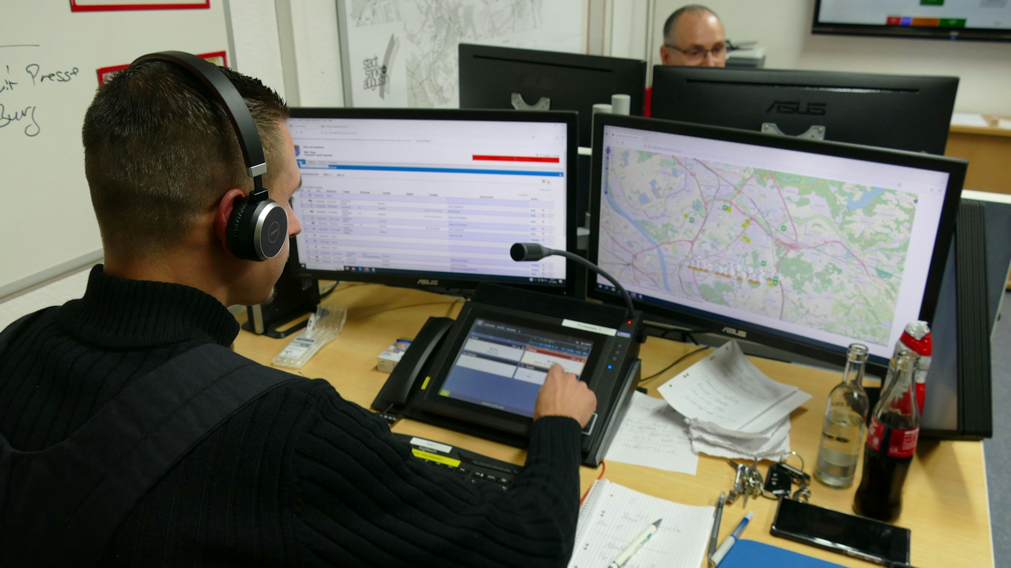 In der Fernmeldezentrale in der Wache Hangelar sitzen vier Ehrenamtliche und leiten die Einsätze per Funk an die Kräfte auf den Fahrzeugen weiter.