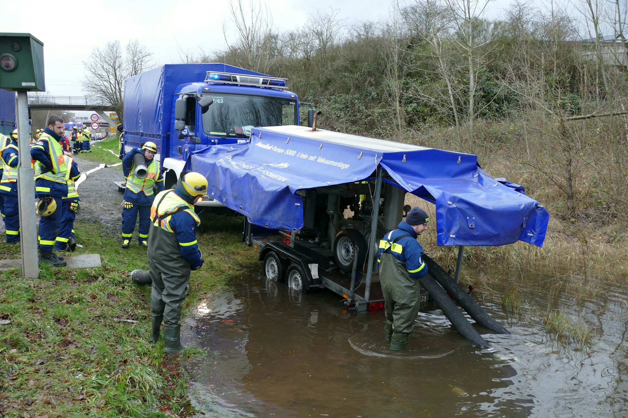 Eine Pumpe auf einem Anhänger steht in einer großen Pfütze.