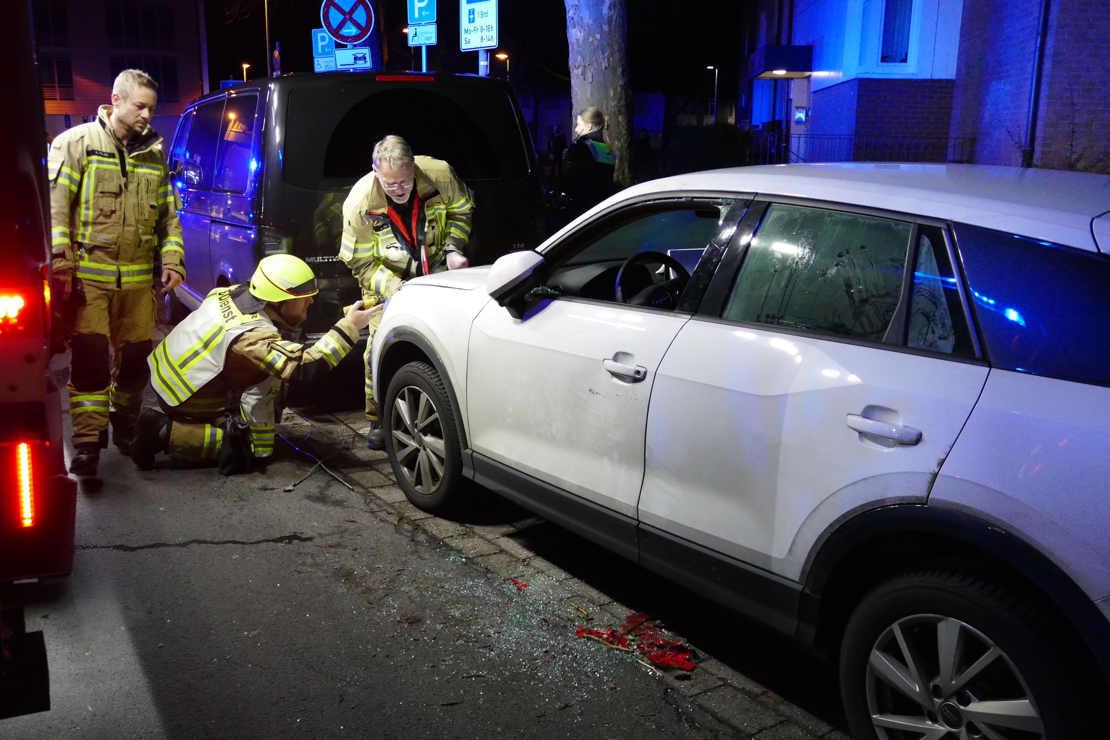 Rettungskräfte stehen am einem weißen Auto.