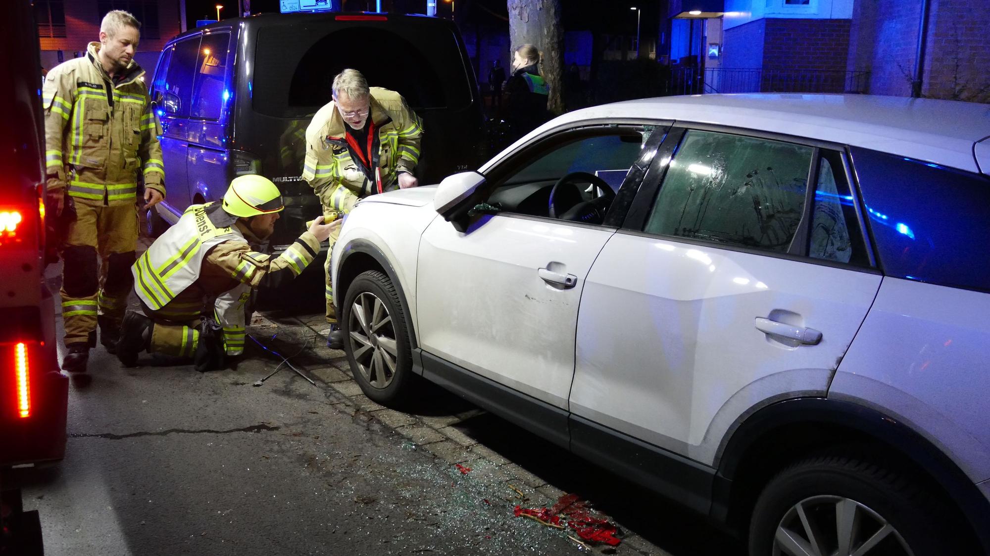 Rettungskräfte stehen am einem weißen Auto.