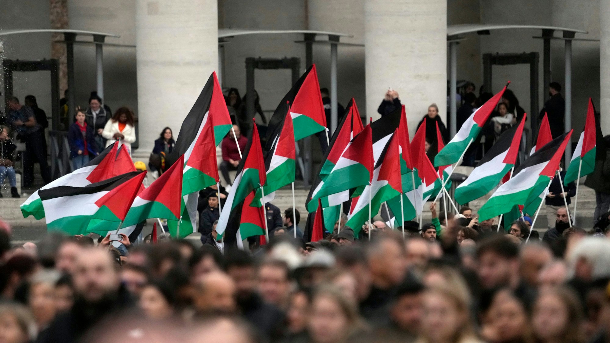 Menschen mit palästinensischen Fahnen kommen zur Weihnachtsbotschaft von Papst Franziskus auf den Petersplatz.
