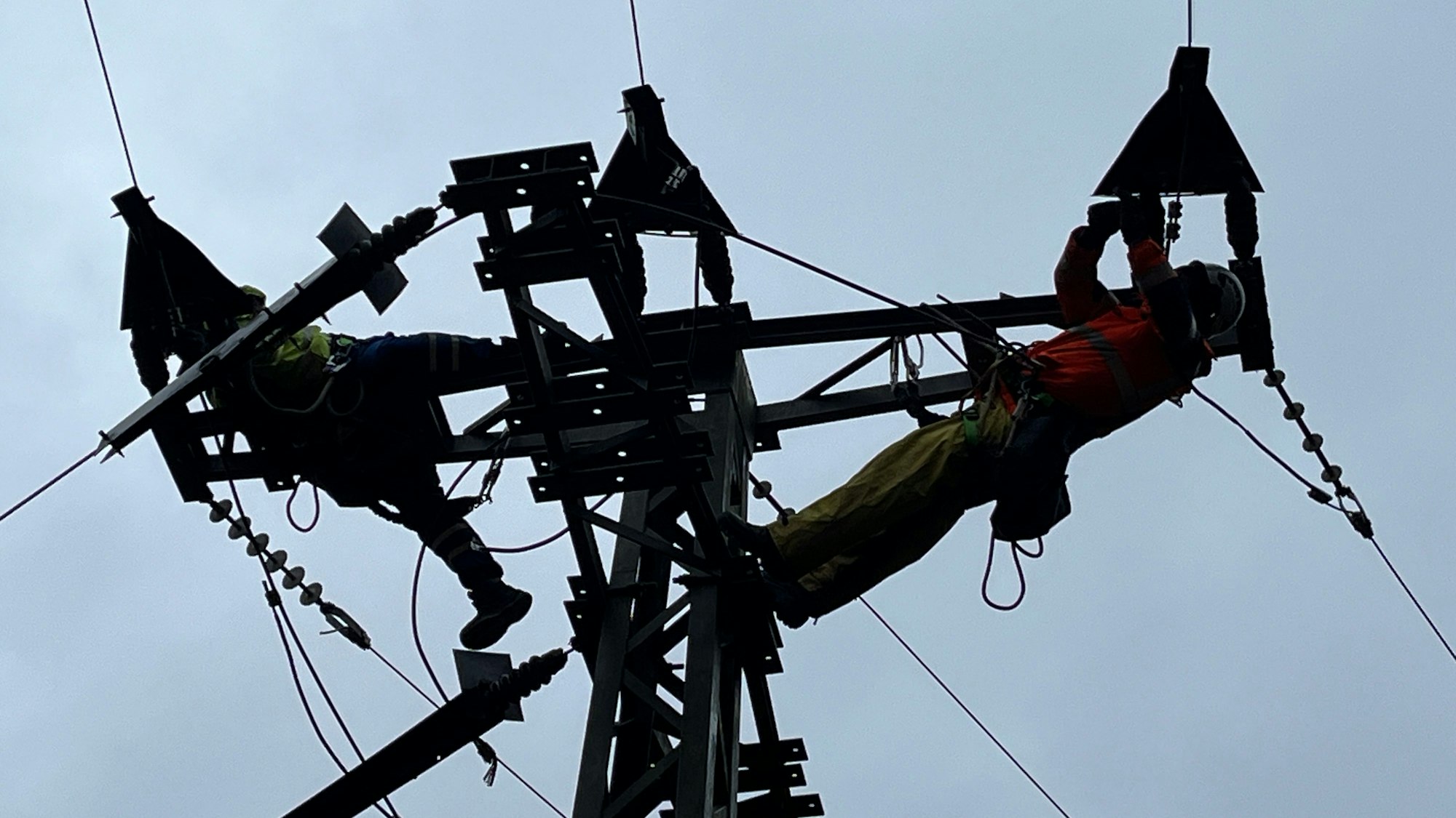 Arbeiten in der Höhe am Stromnetz: Zwei Techniker reparieren die Leitungen.