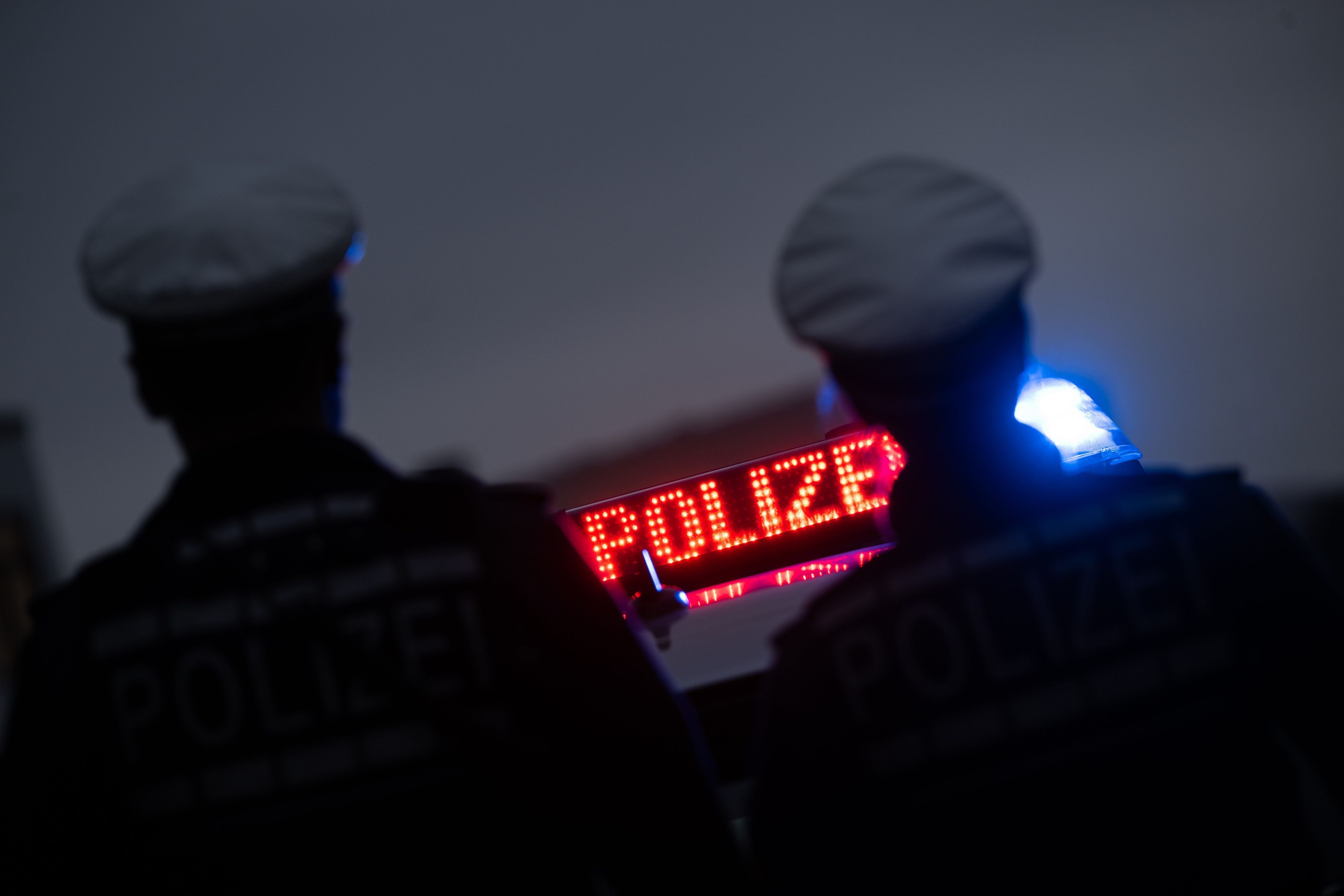 ARCHIV - 30.11.2023, Baden-Württemberg, Stuttgart: ILLUSTRATION - Zwei Polizisten stehen im Rahmen eines Fototermins vor einem Polizeifahrzeug. Die unabhängige Bundesbeauftragte für Antidiskriminierung, Ferda Ataman, hat den Reformentwurf zum Polizeigesetz als einseitig kritisiert. Foto: Marijan Murat/dpa +++ dpa-Bildfunk +++