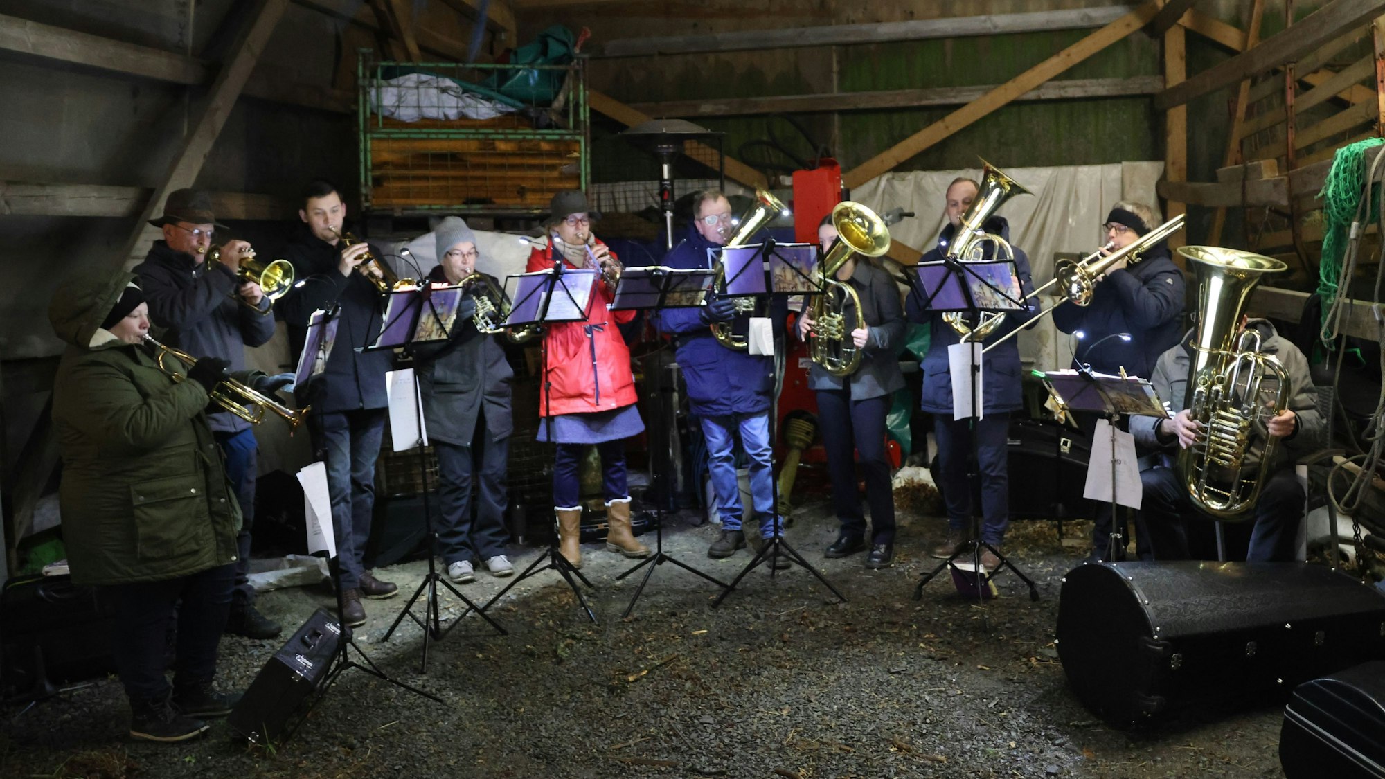 Ein Posaunenchor spielt in einer Remise eines landwirtschaftlichen Betriebs.