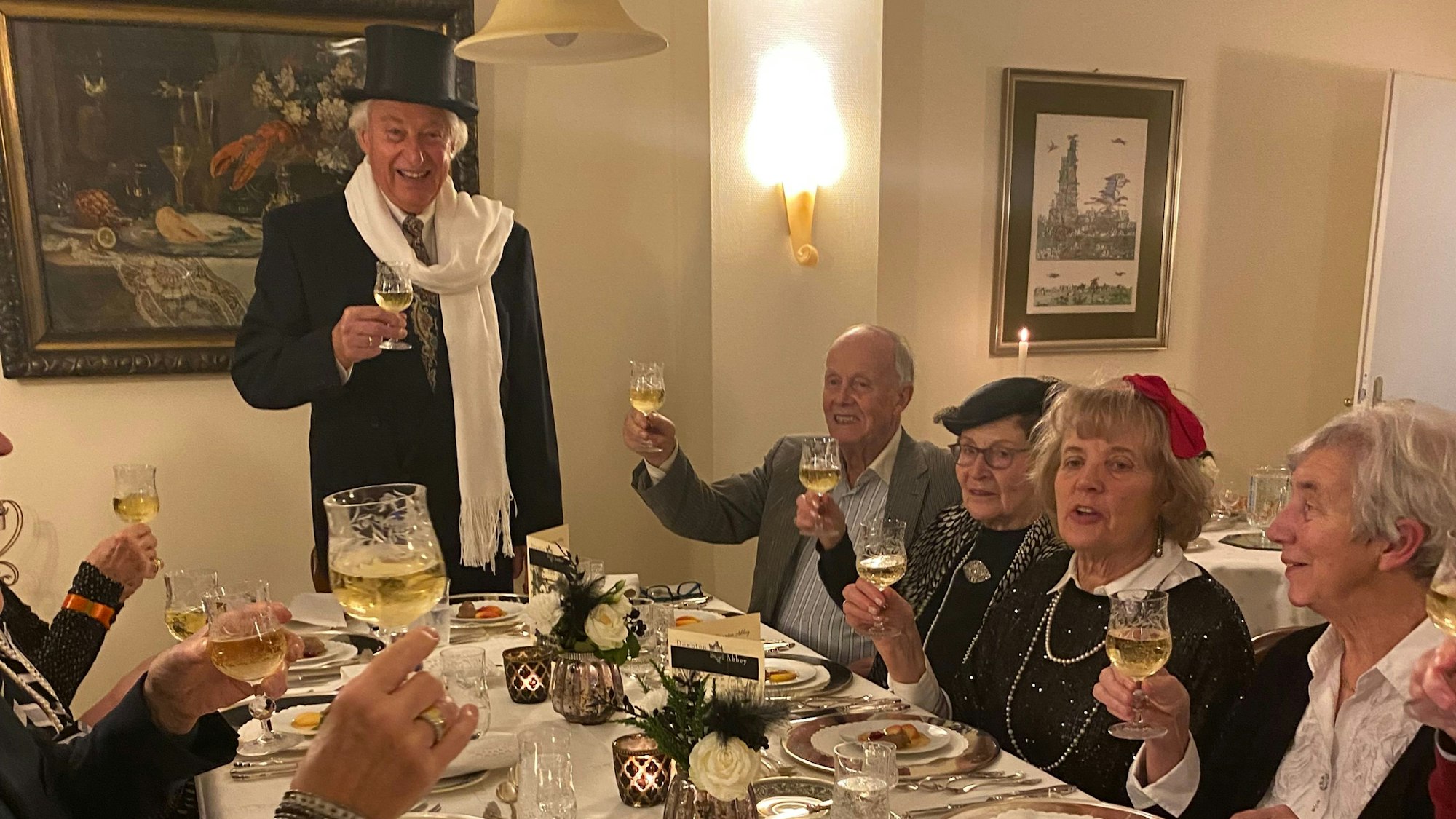 Die Teilnehmer sitzen am Tisch und prosten sich zu.