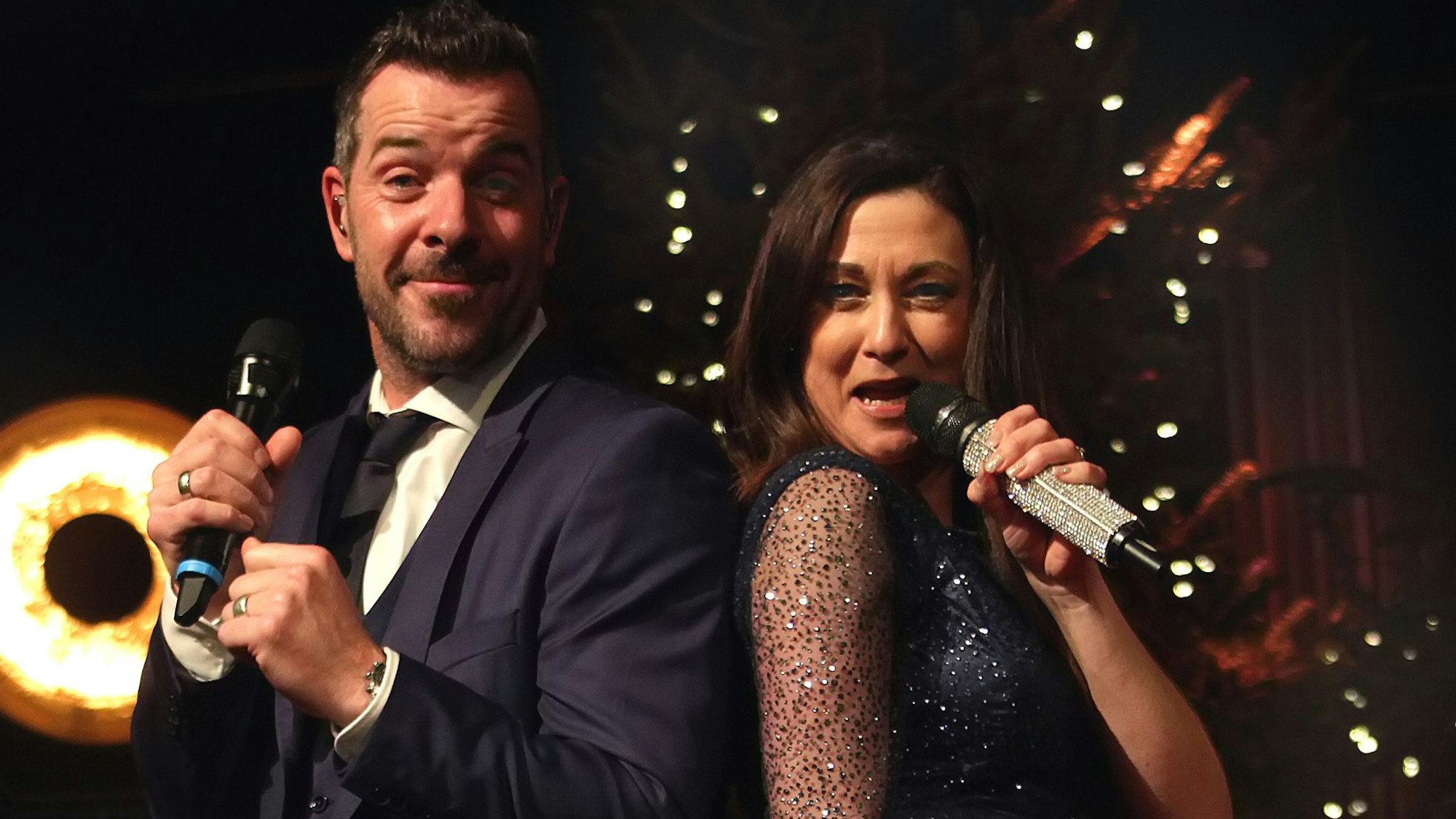 Eine Frau und ein Mann singen auf einer Bühne.