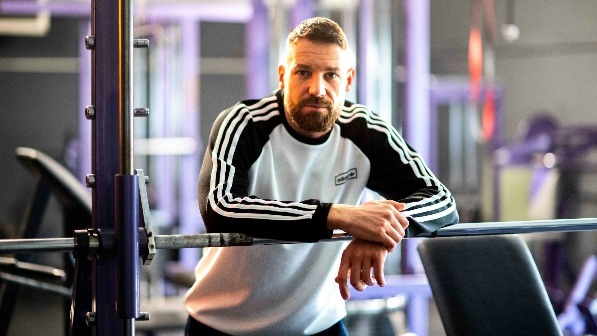 Boxer Benjamin Blindert lehnt über einer Hantelstange.