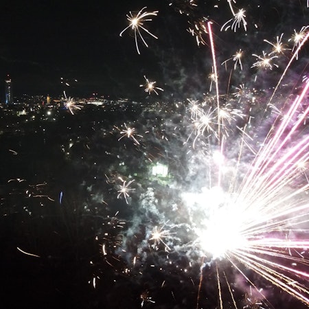 Thüringen, Jena: Explodierende Feuerwerksraketen sind am Nachthimmel über der Altstadt zu sehen. (Aufnahme mit einer Drohne)