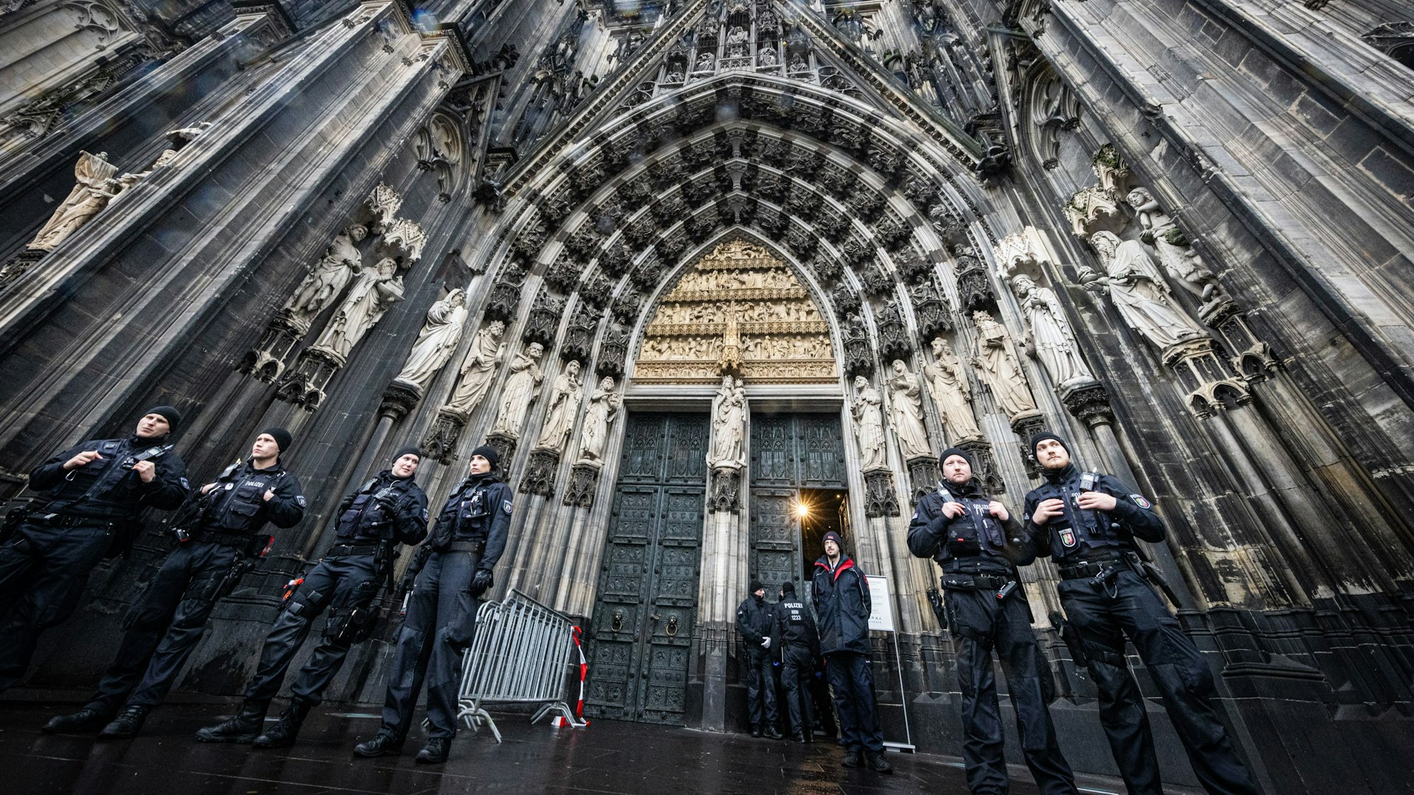 Mehrere Polizisten stehen vor dem Eingang des Doms.