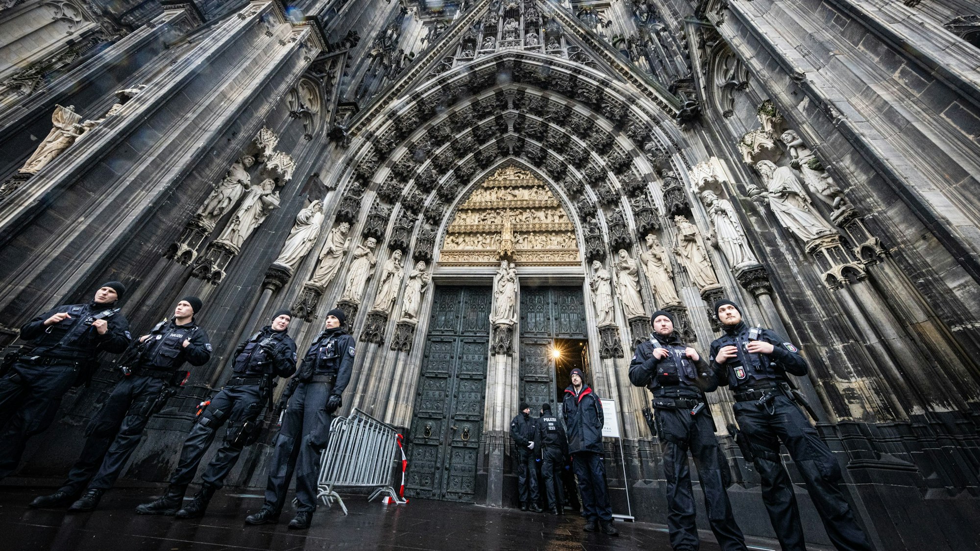 Mehrere Polizisten stehen vor dem Eingang des Doms.