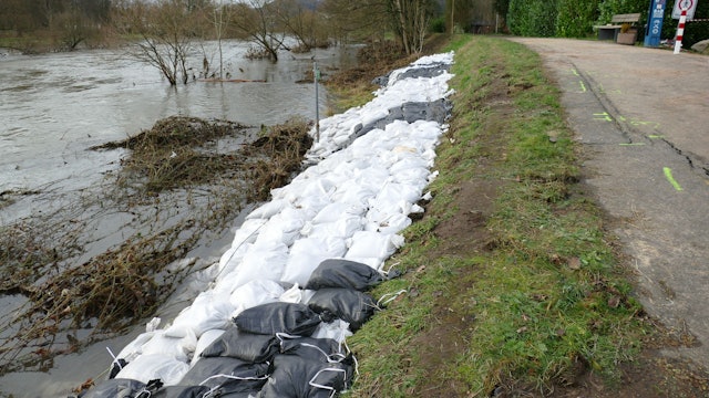 Zahlreiche Sandsäcke sichern einen Deich.
