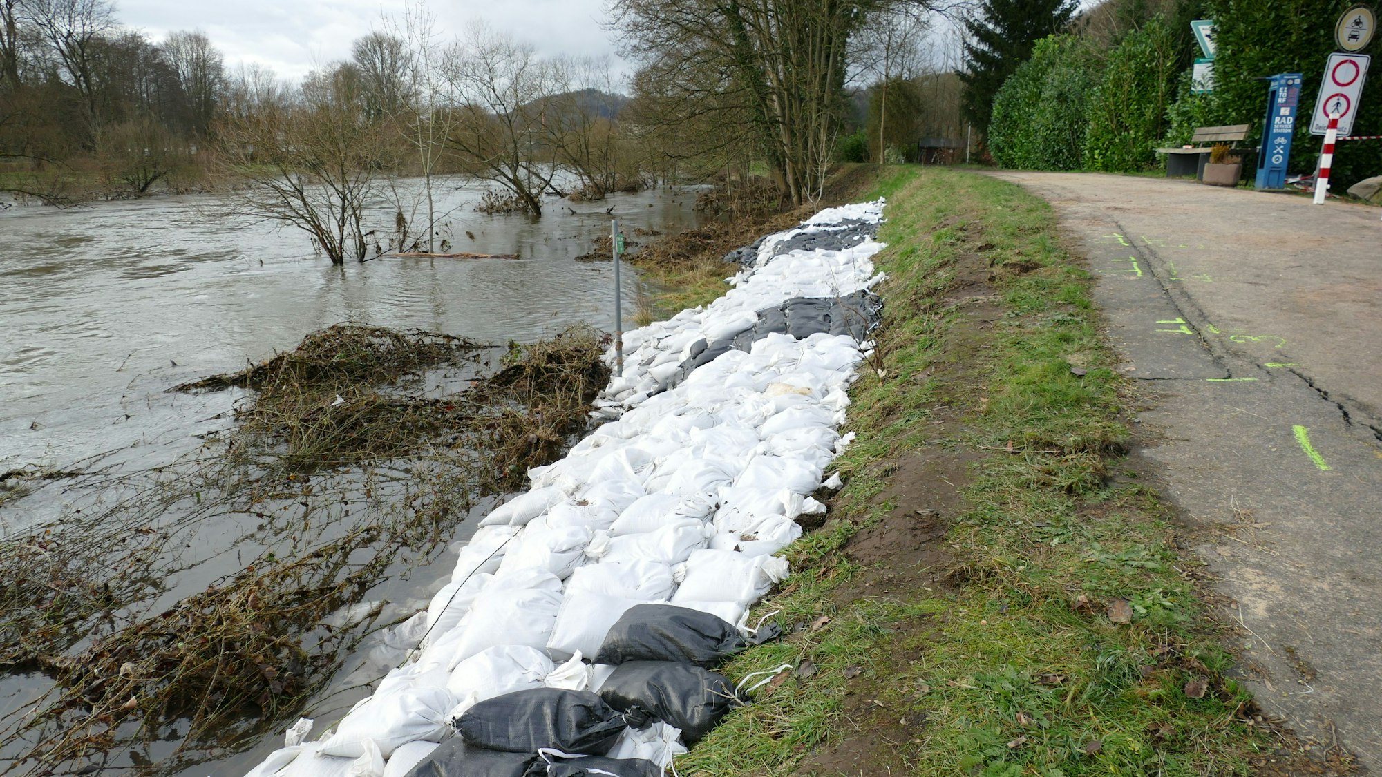 Zahlreiche Sandsäcke sichern einen Deich.