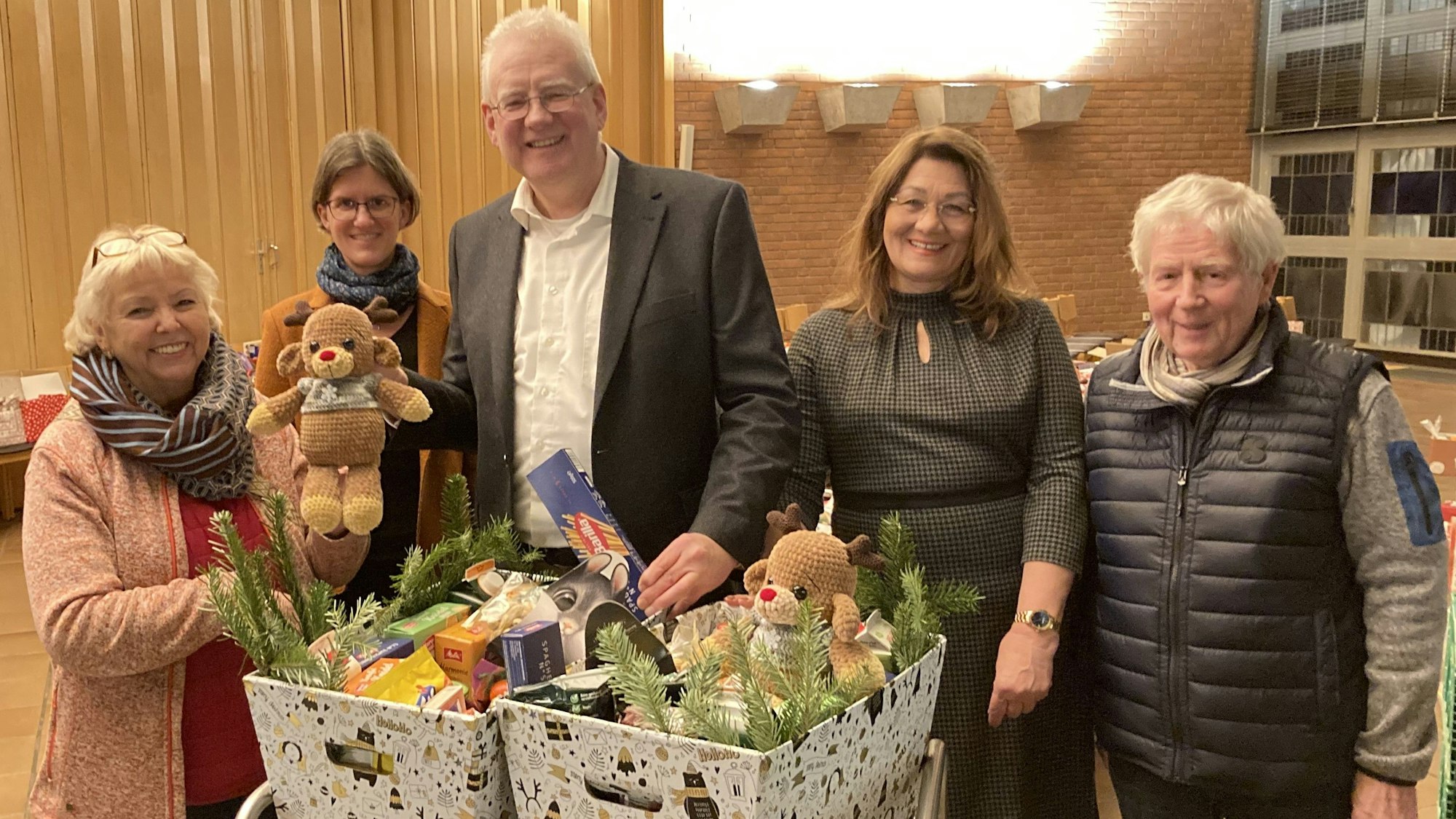 Fünf Mitglieder der Kirchengemeinde freuen sich über die gelungene Spendenaktion. Sie präsentieren mit Geschenken gefüllte „Weihnachtskisten.“