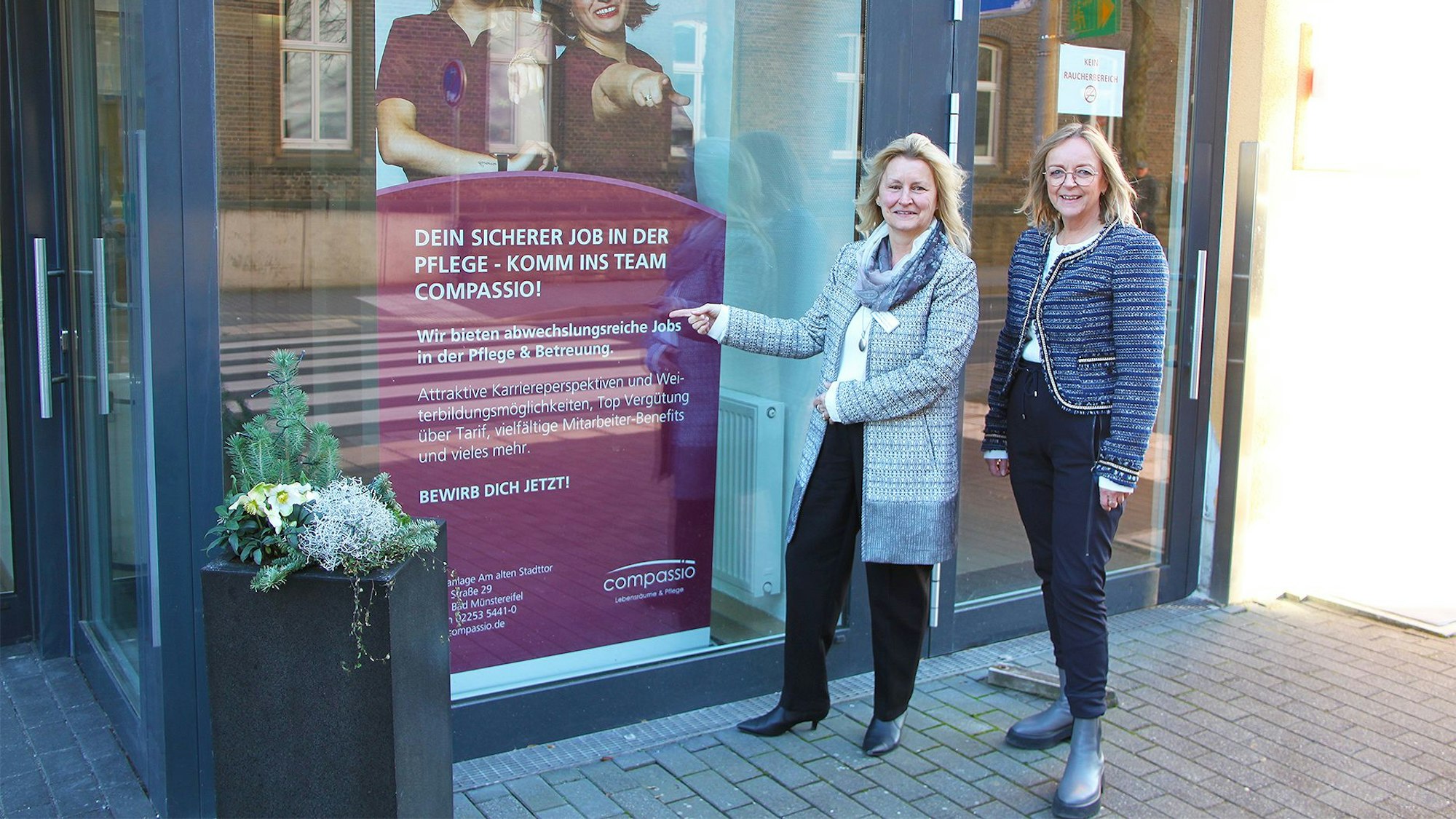 Karola dos Santos Ramos steht vor dem Eingang zu der Pflegeeinrichtung in Bad Münstereifel, die sie nun leitet. Rechts neben ihr steht Sabine Preiser-Marian.