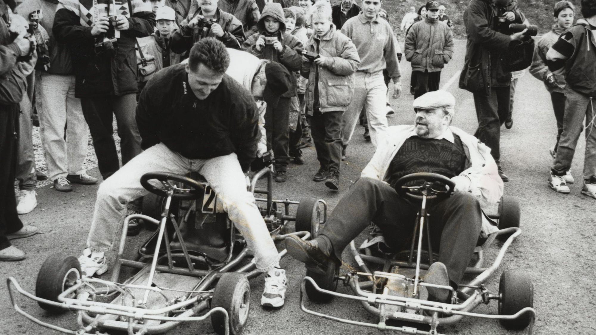 Ein schwarz-weiß Foto von Michael Schumacher, der auf einem alten Kart sitzt.