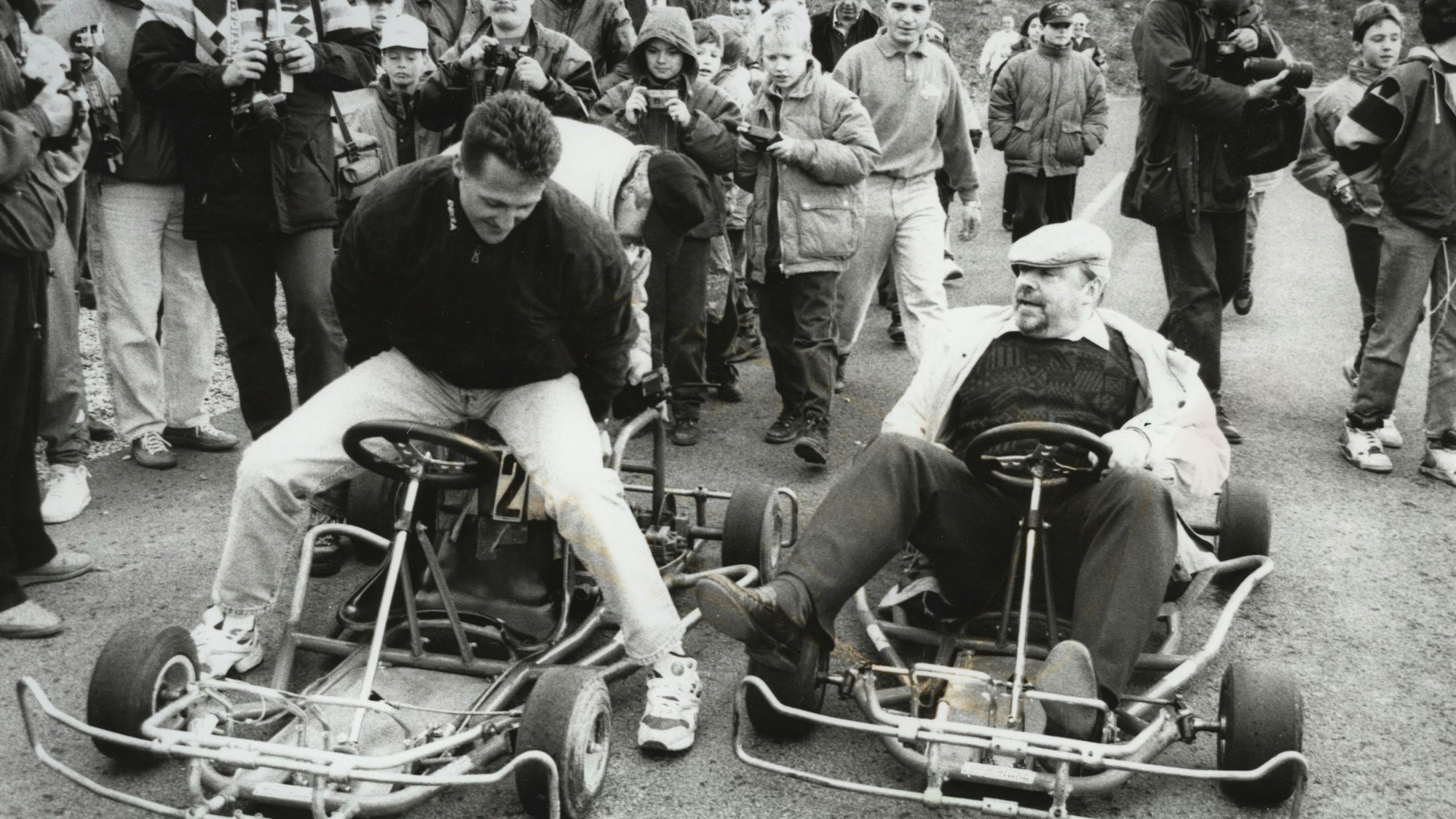 Ein schwarz-weiß Foto von Michael Schumacher, der auf einem alten Kart sitzt.