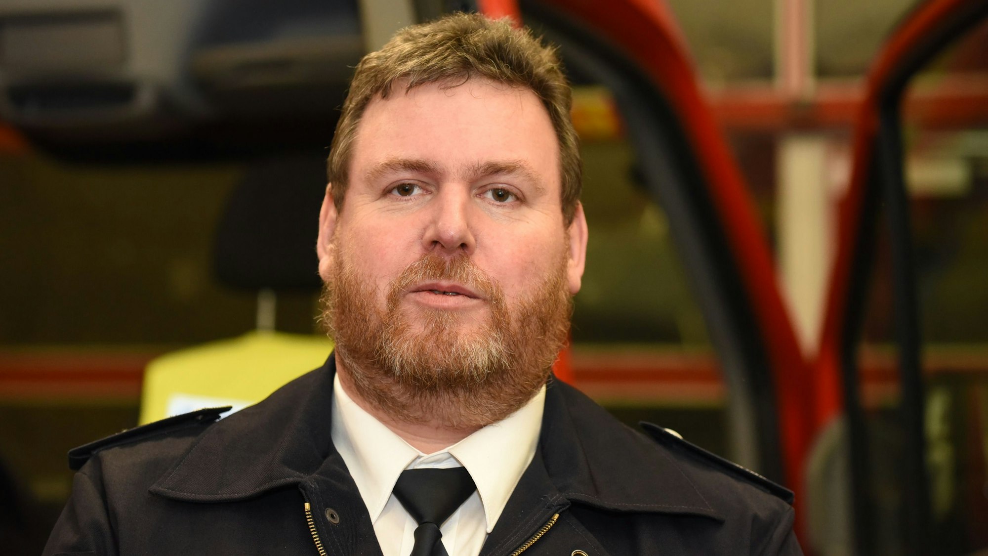 Der Leiter der Feuerwehr Kürten, Stefan Landwehr, steht in einem Feuerwehrhaus.