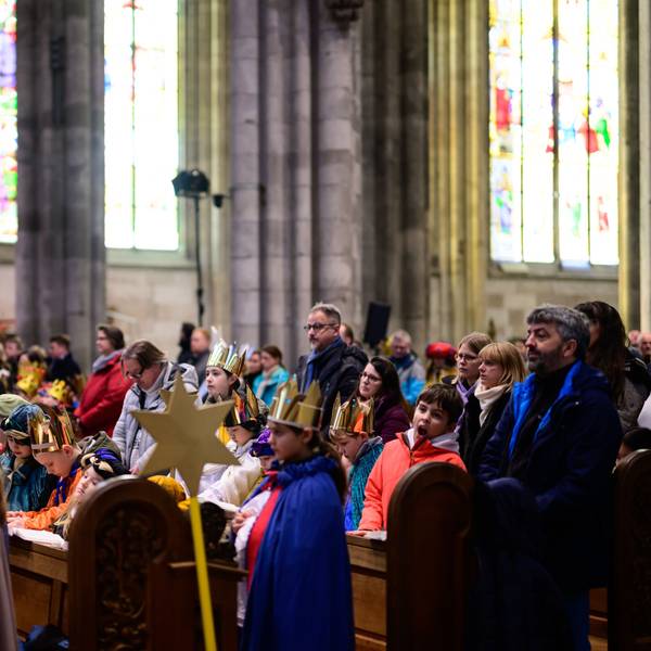 Sternsinger sitzen im Kölner Dom
