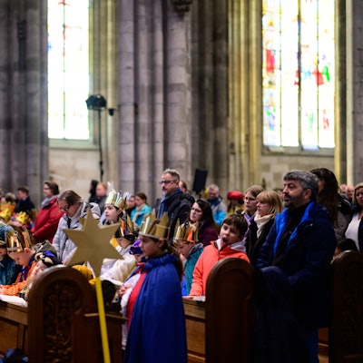 Sternsinger sitzen im Kölner Dom